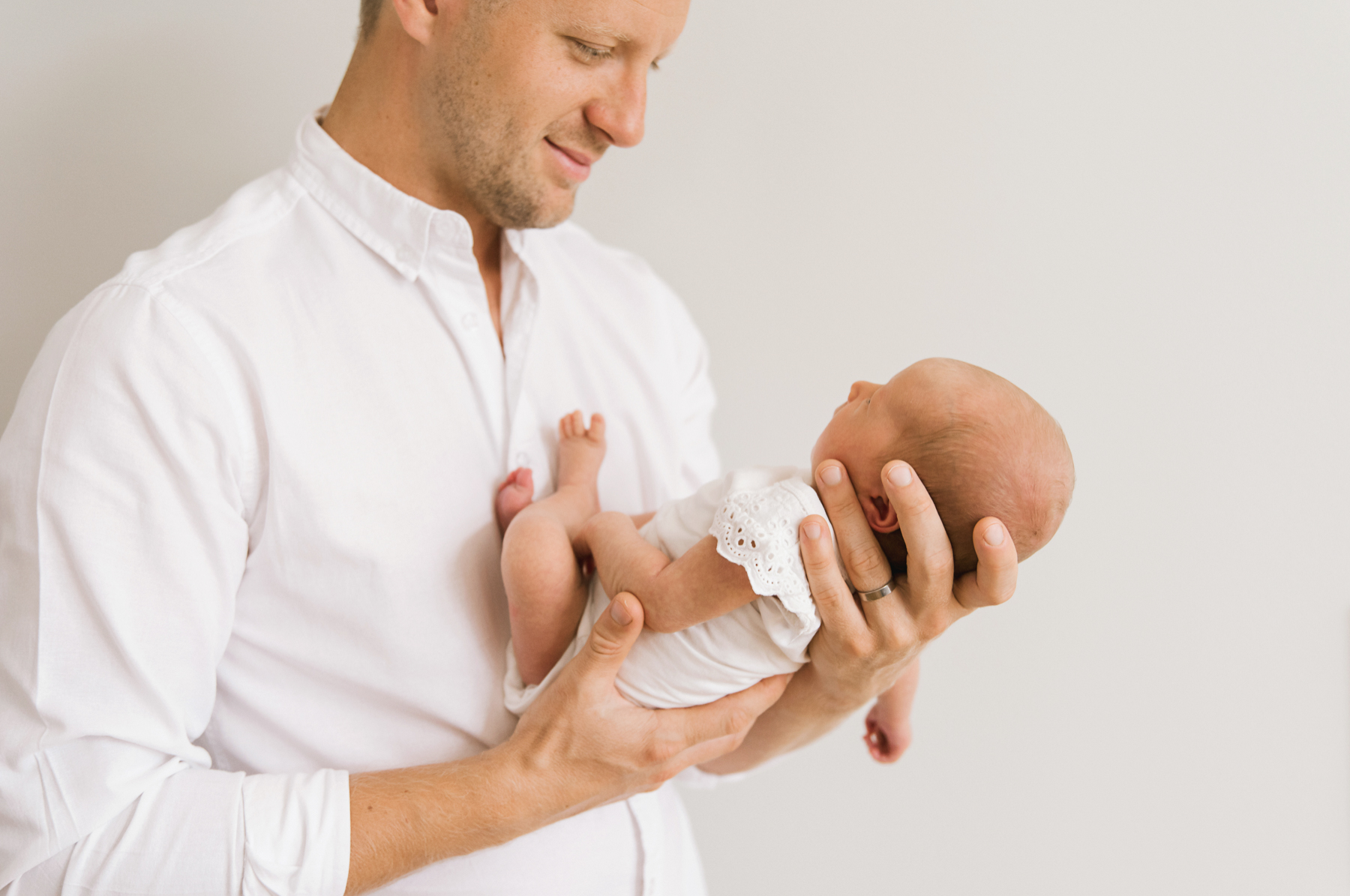 Lifestyle newborn session, dad holding baby