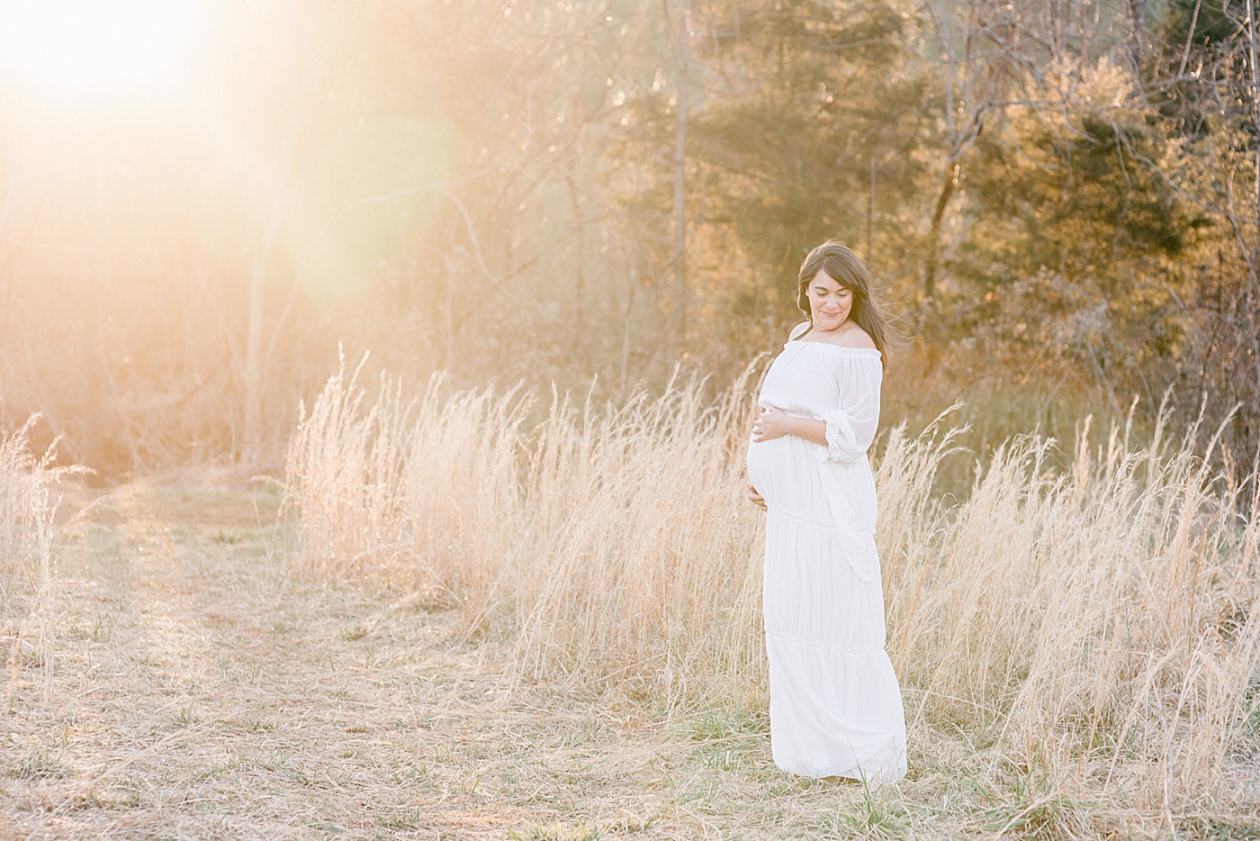 Mother to be in a white dress with golden light during maternity session | Photo by Anna Wisjo Photography