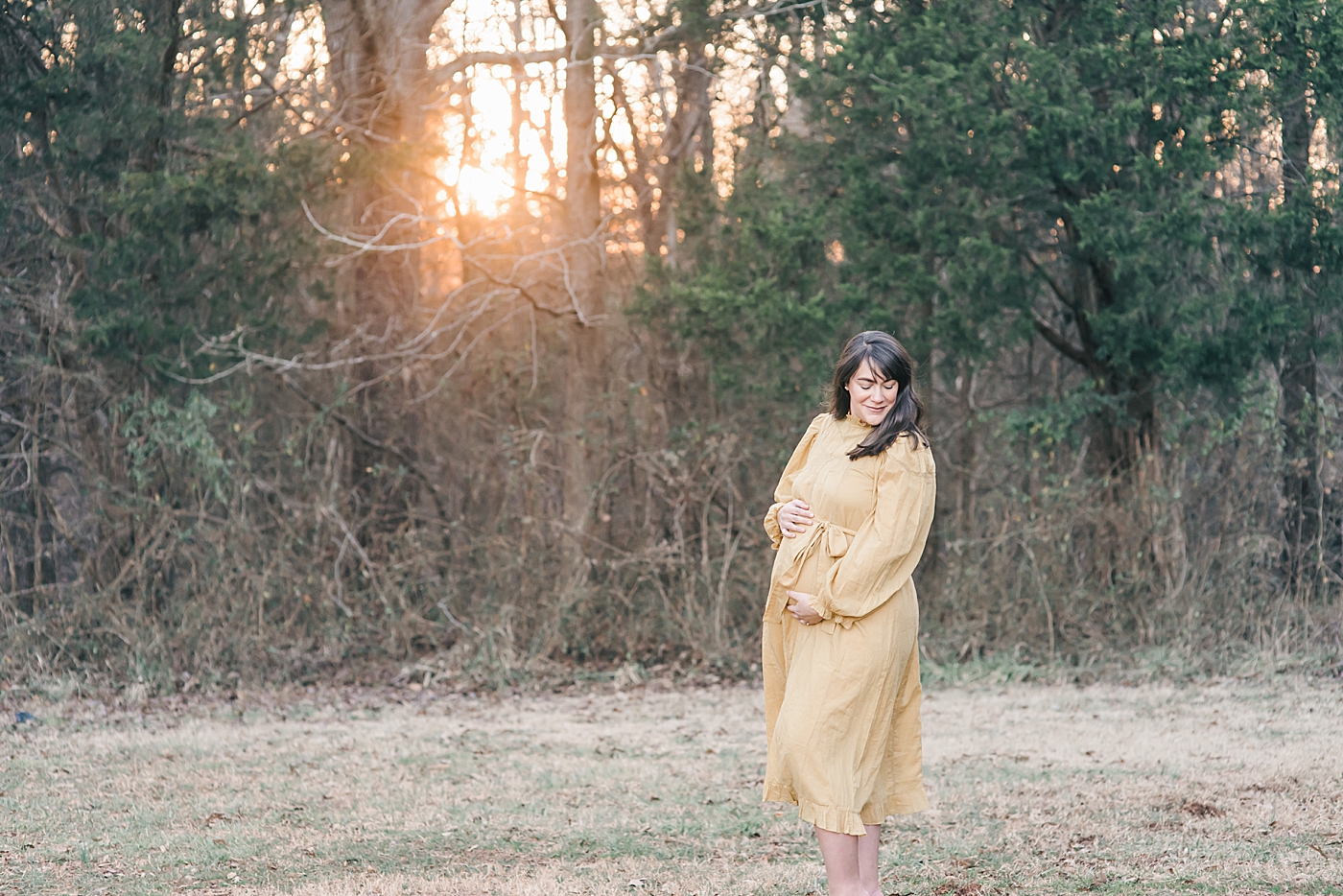 Pregnant woman in yellow dress in a field at sunset at fisher farm park | Photo by Anna Wisjo Photography