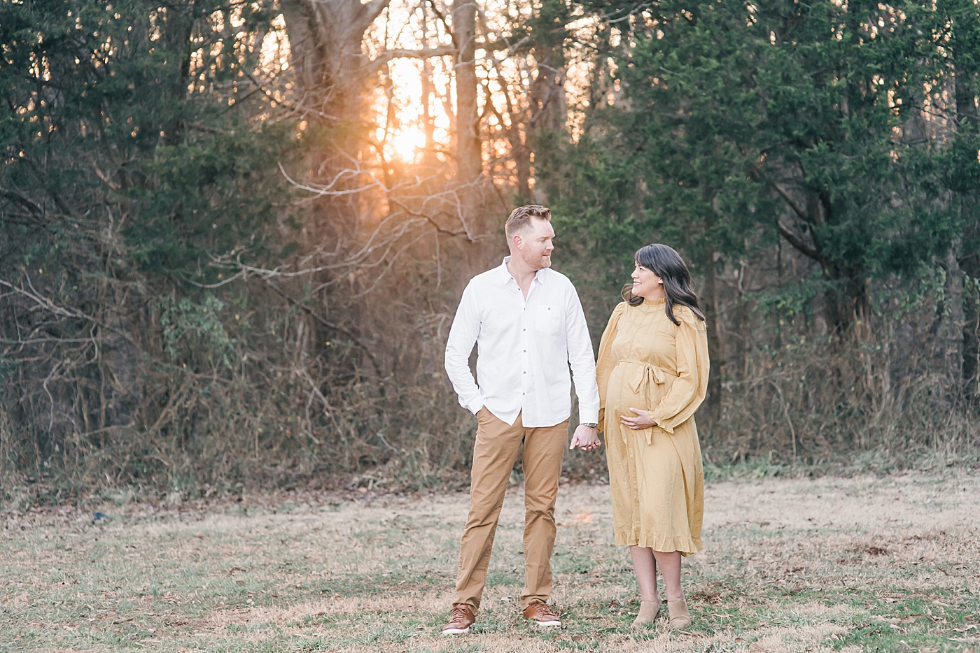 Father and mother to be in a field during maternity session | Photo by Anna Wisjo Photography