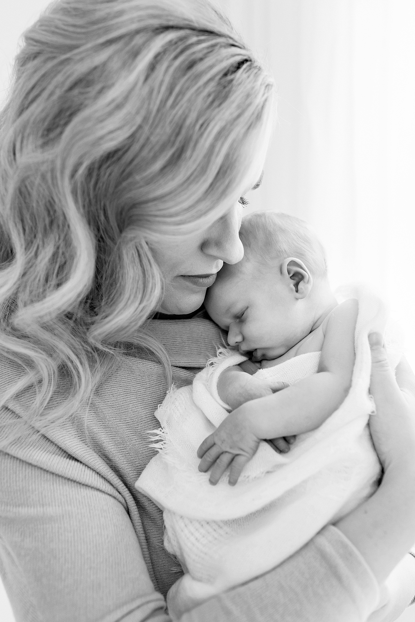 Black and white photo of mom snuggling newborn baby boy | Photo by Anna Wisjo Photography