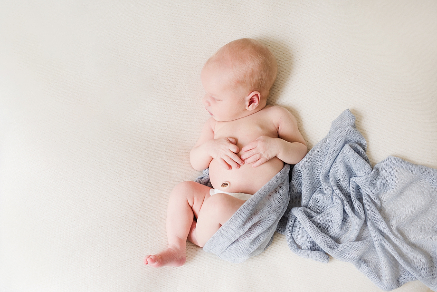 baby boy wrapped in pale blue swaddle | Photo by Anna Wisjo Photogrpahy