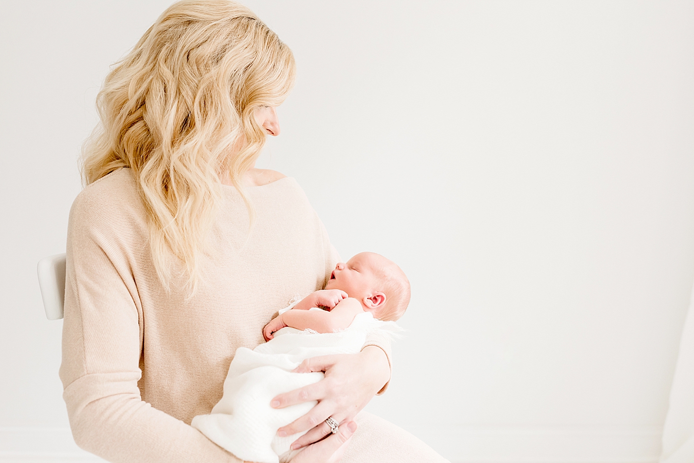 Mom holding newborn baby during studio session | Photo by Anna Wisjo Photography
