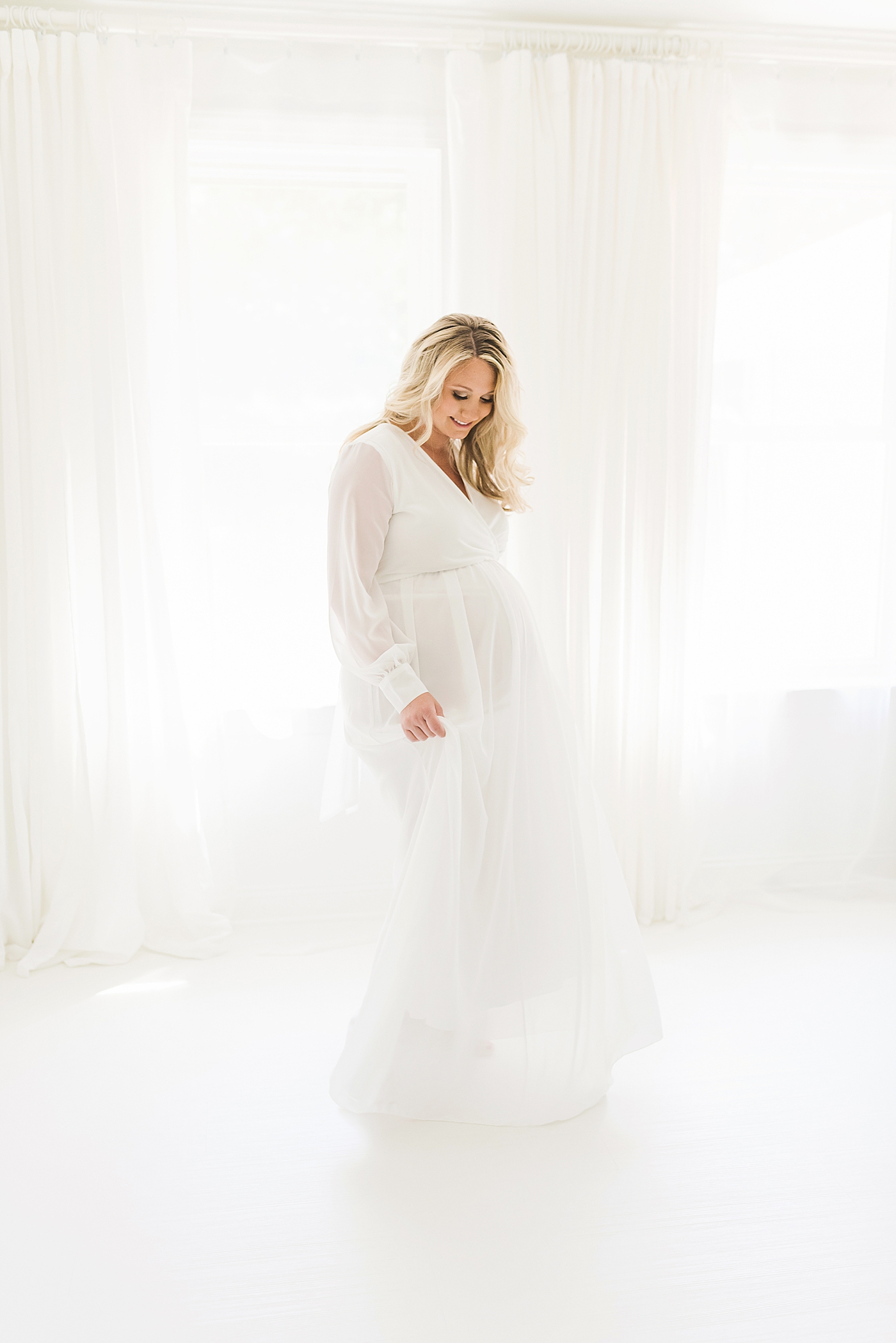 Mother to be twirling in sheer white dress | Photo by Anna Wisjo Photography