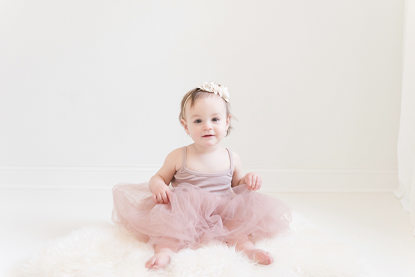 Baby girl in pink tutu sitting on white background | Photo by Anna Wisjo Photography