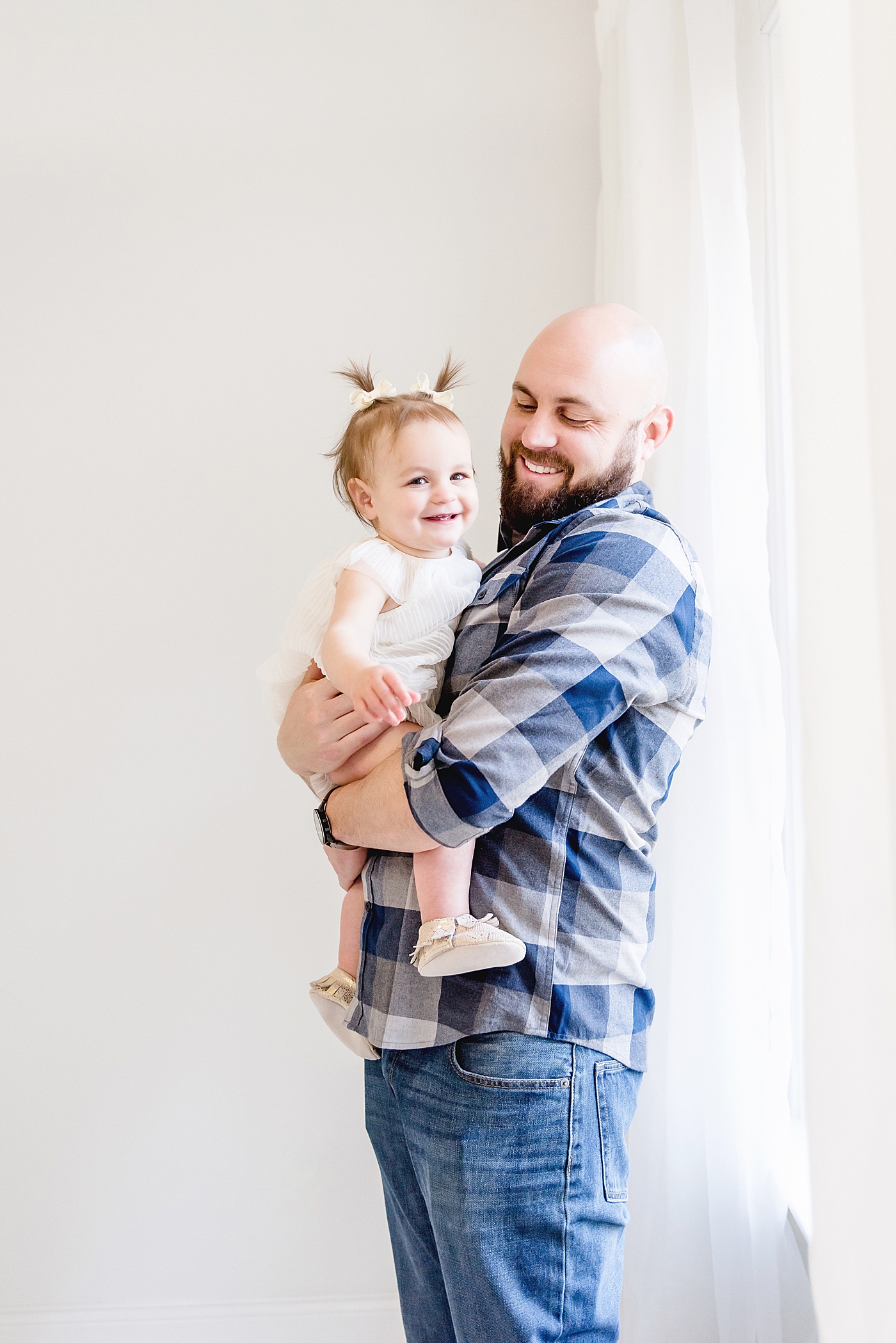 Dad in blue and baby girl smile at the camera | Photo by Anna Wisjo Photography