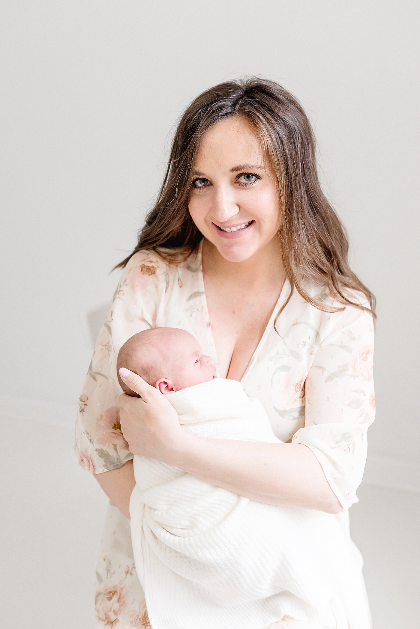 Mom holding newborn looking at the camera during studio session | Anna Wisjo Photography