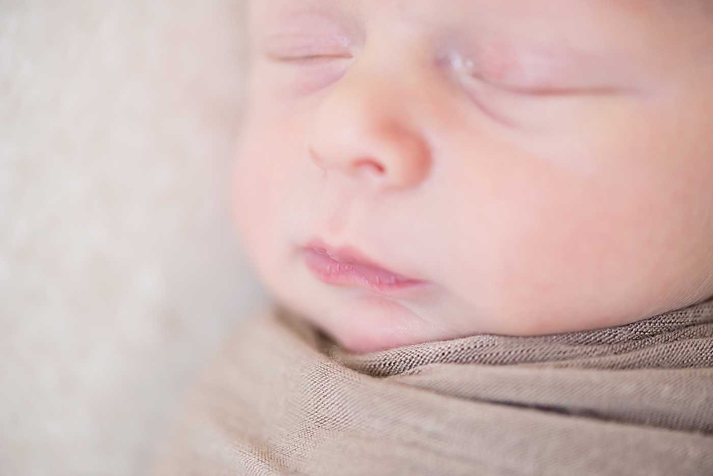 Baby boy sleeping wrapped in soft brown swaddle | Photo by Anna Wisjo