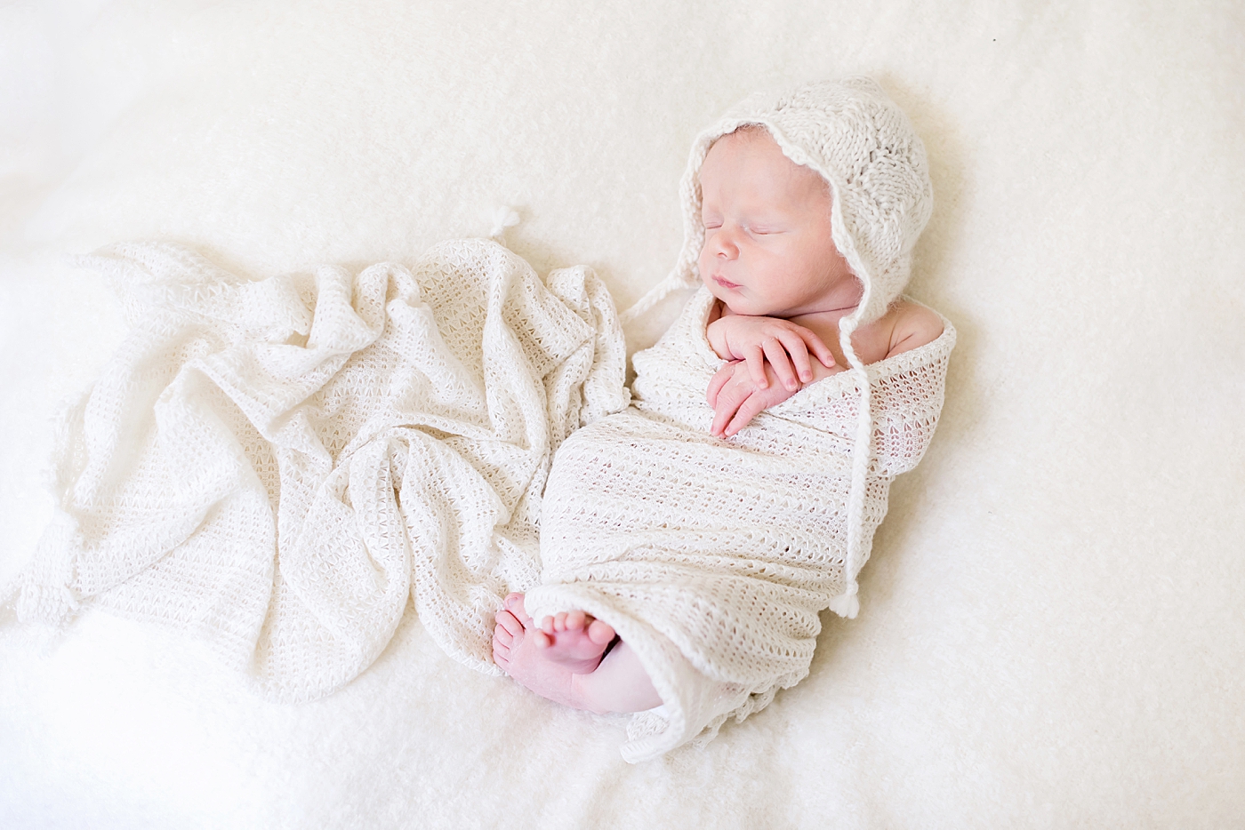 Newborn baby in knitted swaddle and hat | Photo by Charlotte NC Newborn Photographer Anna Wisjo