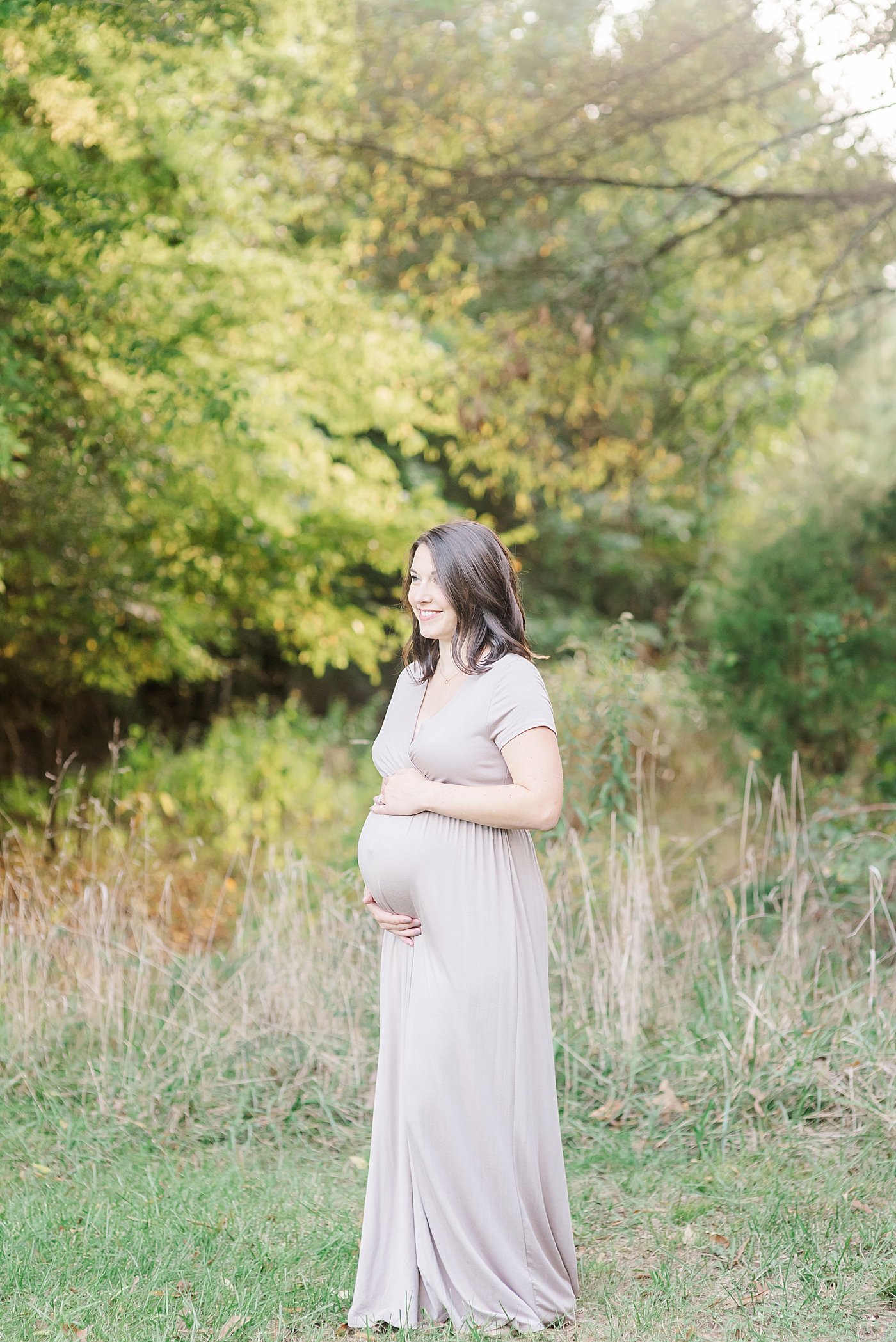 Mom to be in mauve dress smiling | Photo by Anna Wisjo