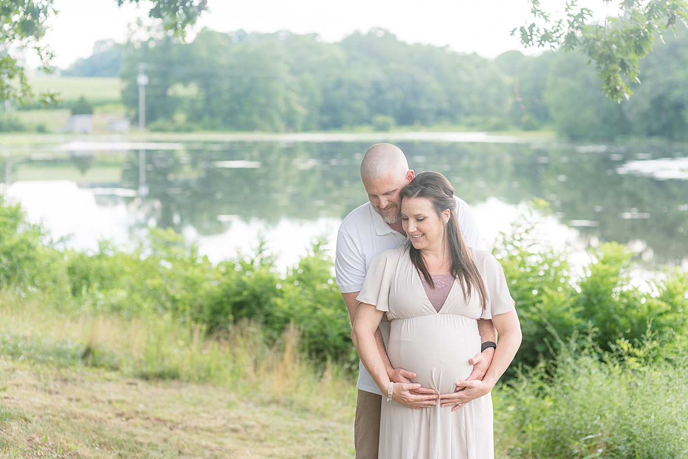 Mom and dad holding moms growing belly | Photo by Anna Wisjo Photography