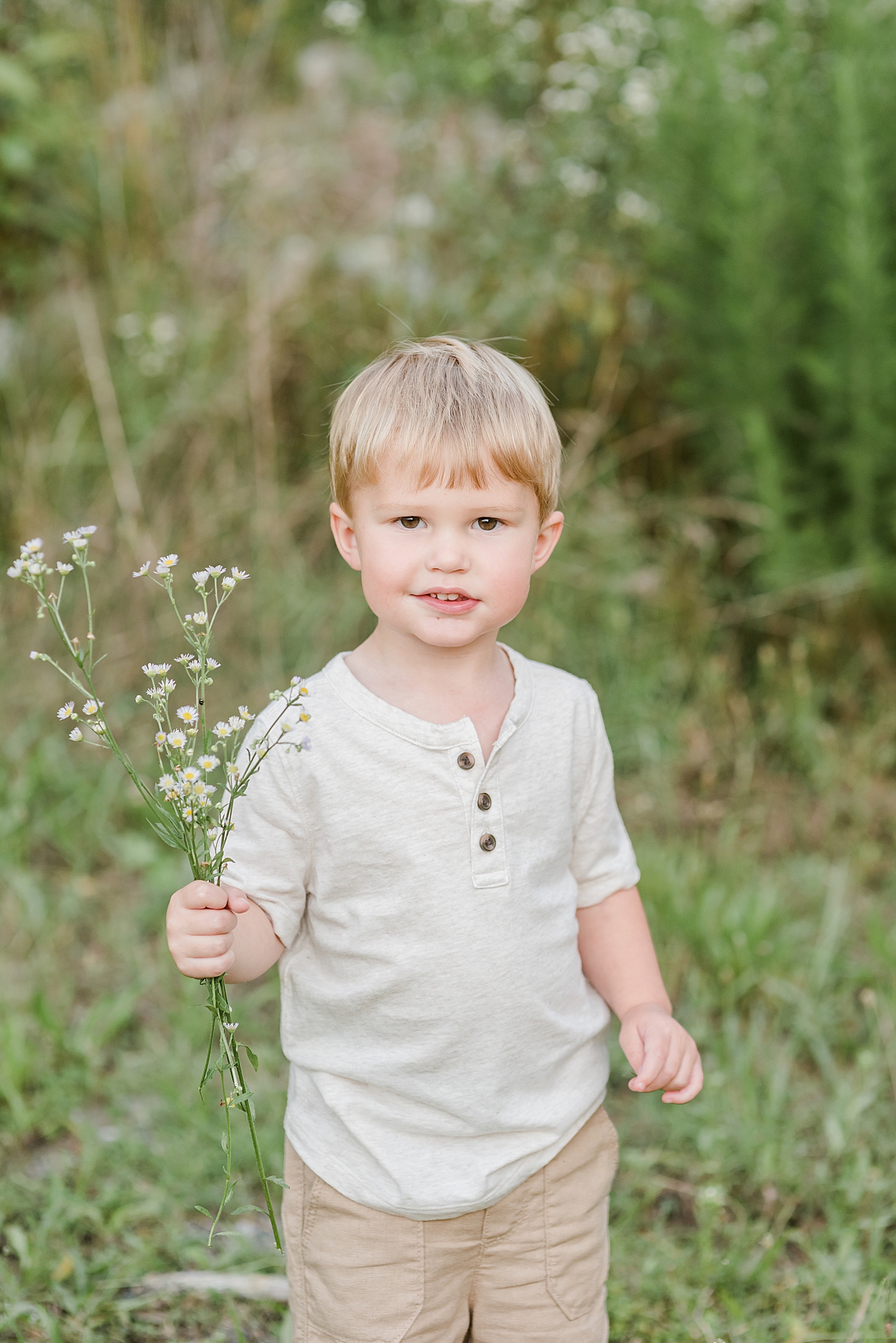 Little boy in cream shirt picking flowers | Photo by Denver NC Maternity Photographer Anna Wisjo