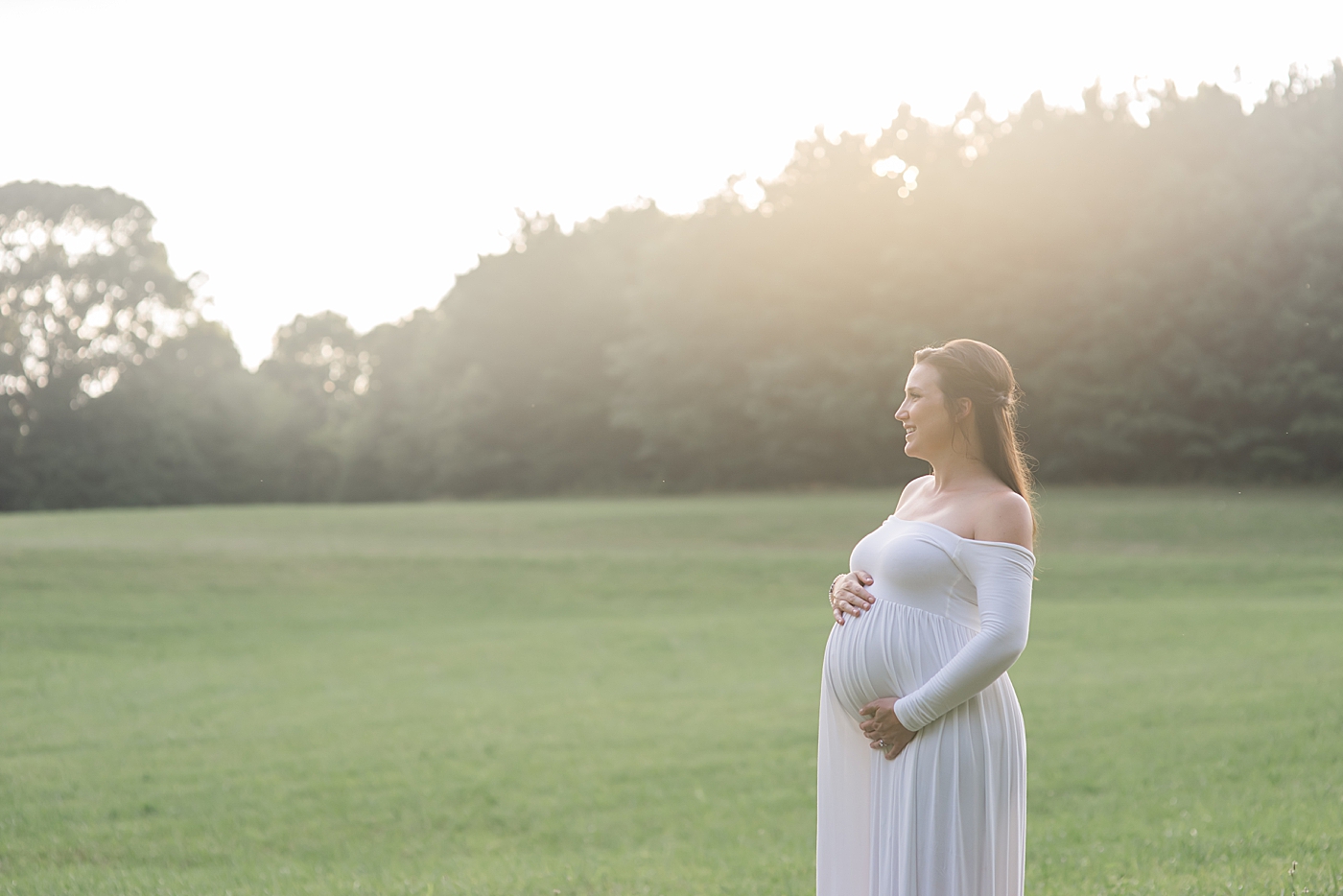 Mom to be in flowing white dress smiling | Photo by Denver NC Maternity Photographer Anna Wisjo