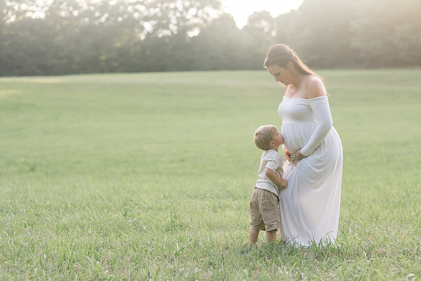 Little boy kissing moms pregnant belly | Photo by Denver NC Maternity Photographer Anna Wisjo