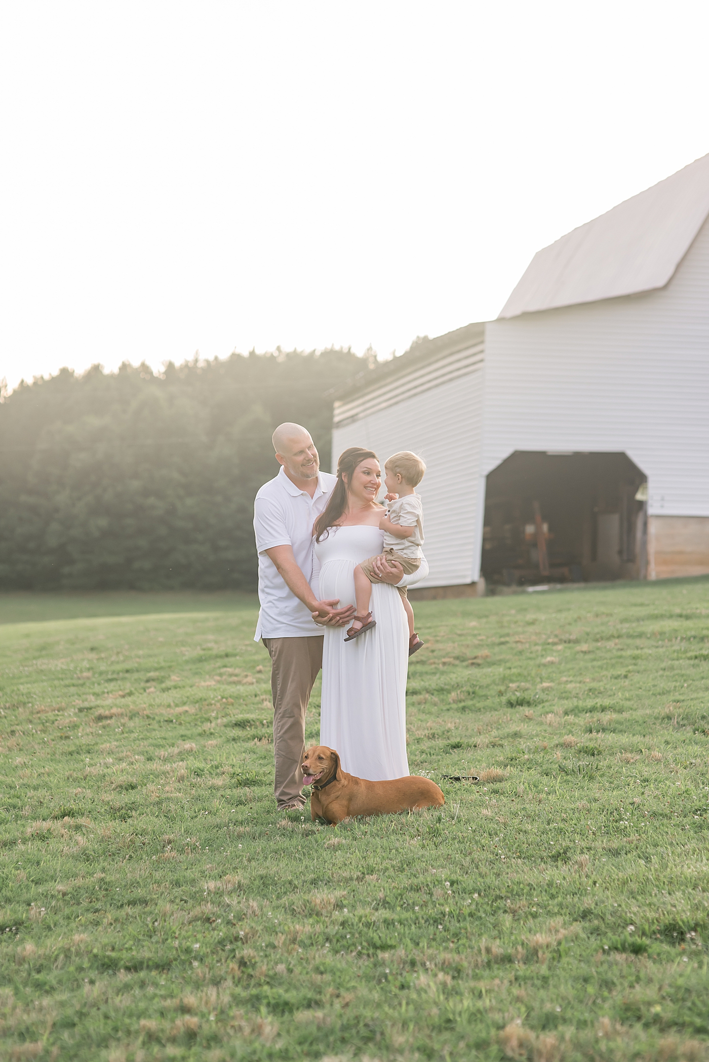 Mom and dad in white smiling at their toddler | Photo by Denver NC Maternity Photographer Anna Wisjo