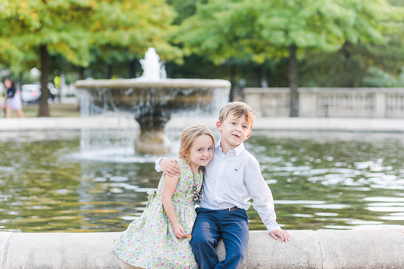 Siblings sitting together at a fountain | Photo by Anna Wisjo Photography