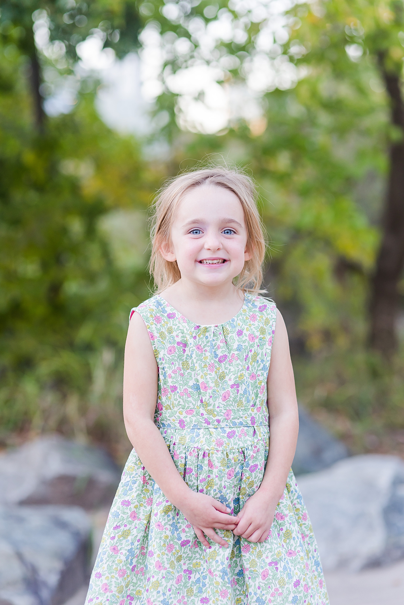 Little girl in floral print dress smiling | Photo by Anna Wisjo Photography