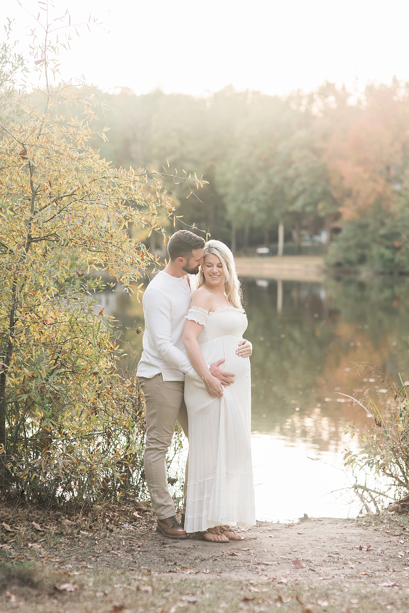 Mom and dad to be by a pond | Photo by Charlotte Maternity Photographer Anna Wisjo 