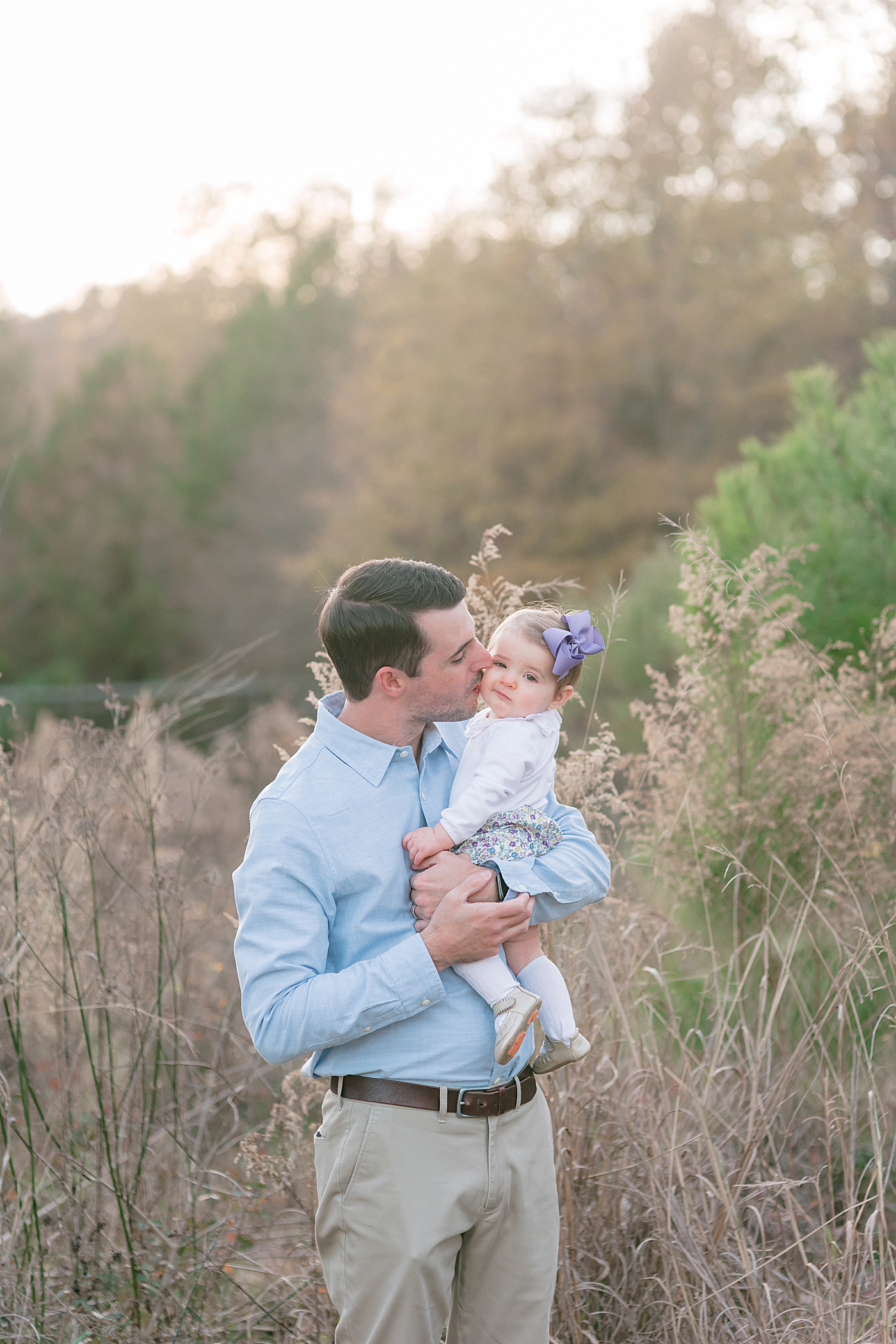 Dad holding his baby girl in floral bloomers during her Milestone Session at Marvin Efird Park | Photo by Anna Wisjo Photography 