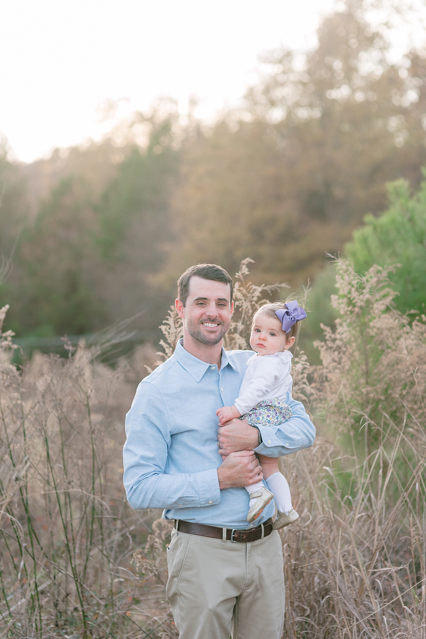 Dad smiling with his baby girl in a field at Milestone Session at Marvin Efird Park | Photo by Anna Wisjo Photography 