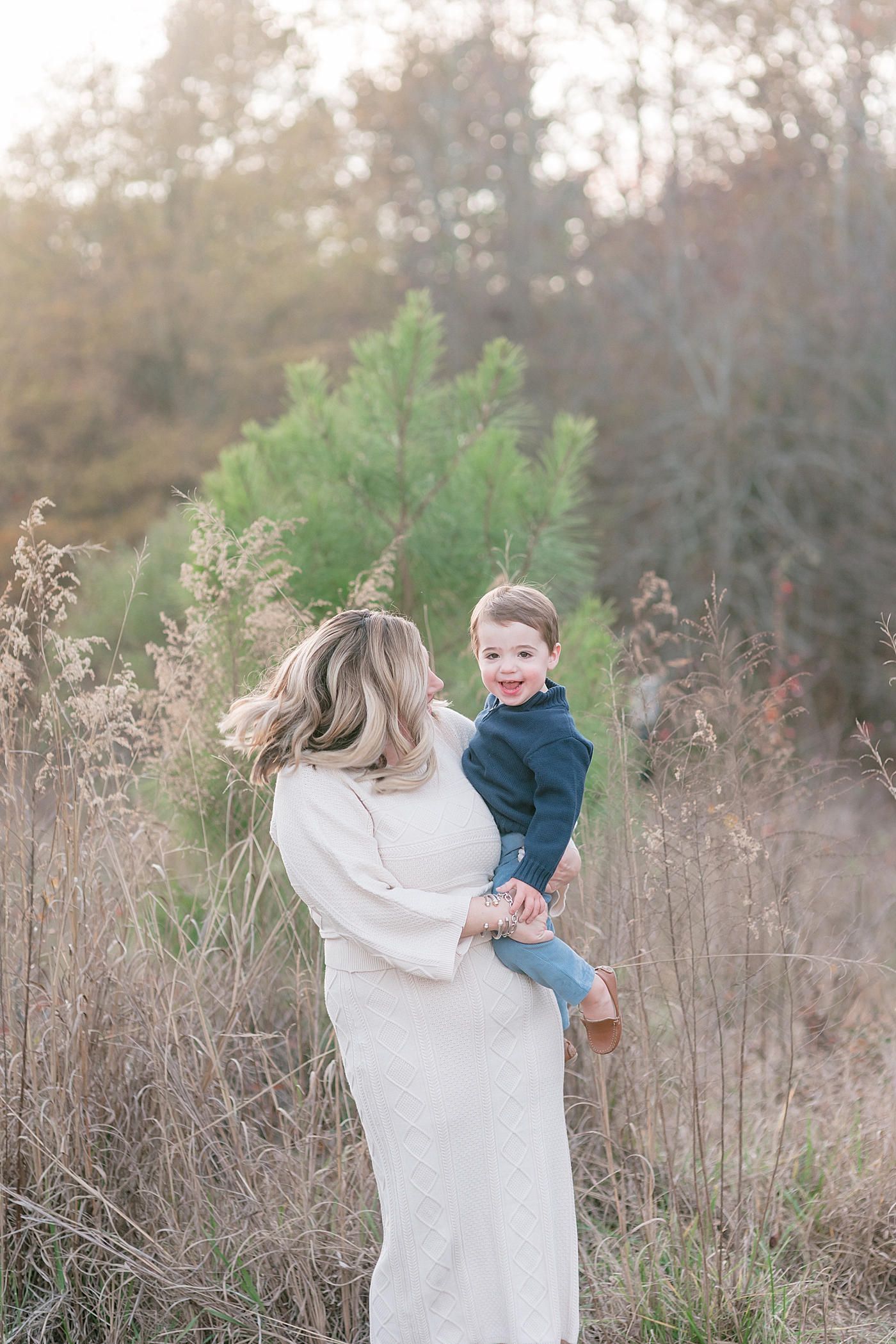 Mom playing with toddler boy in navy in a field | Photo by Anna Wisjo Photography 