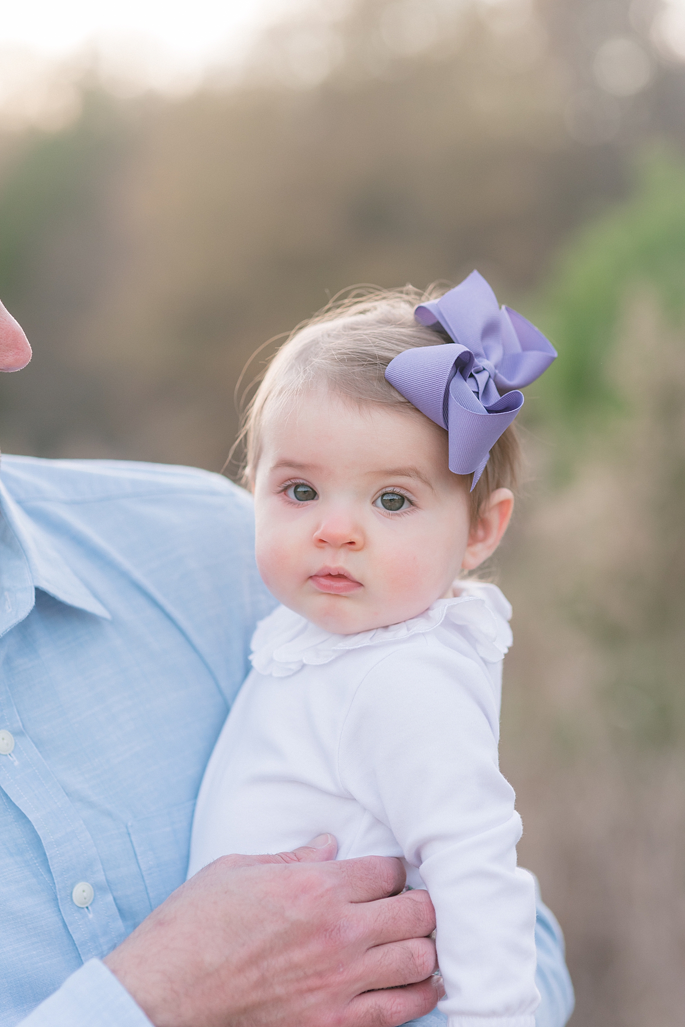 Baby girl in a purple bow and white peter pan top | Photo by Anna Wisjo Photography 