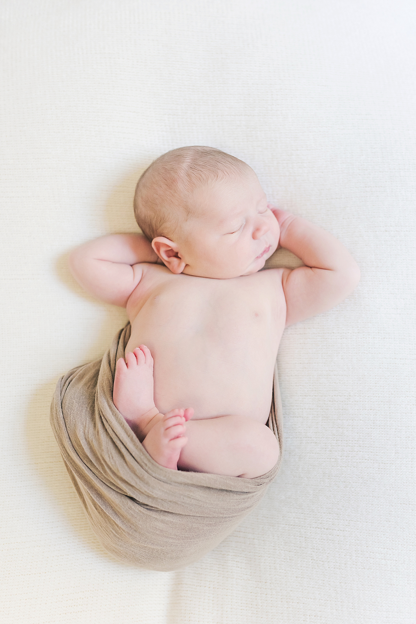 Baby boy in a light brown swaddle | Photo by Anna Wisjo Photography