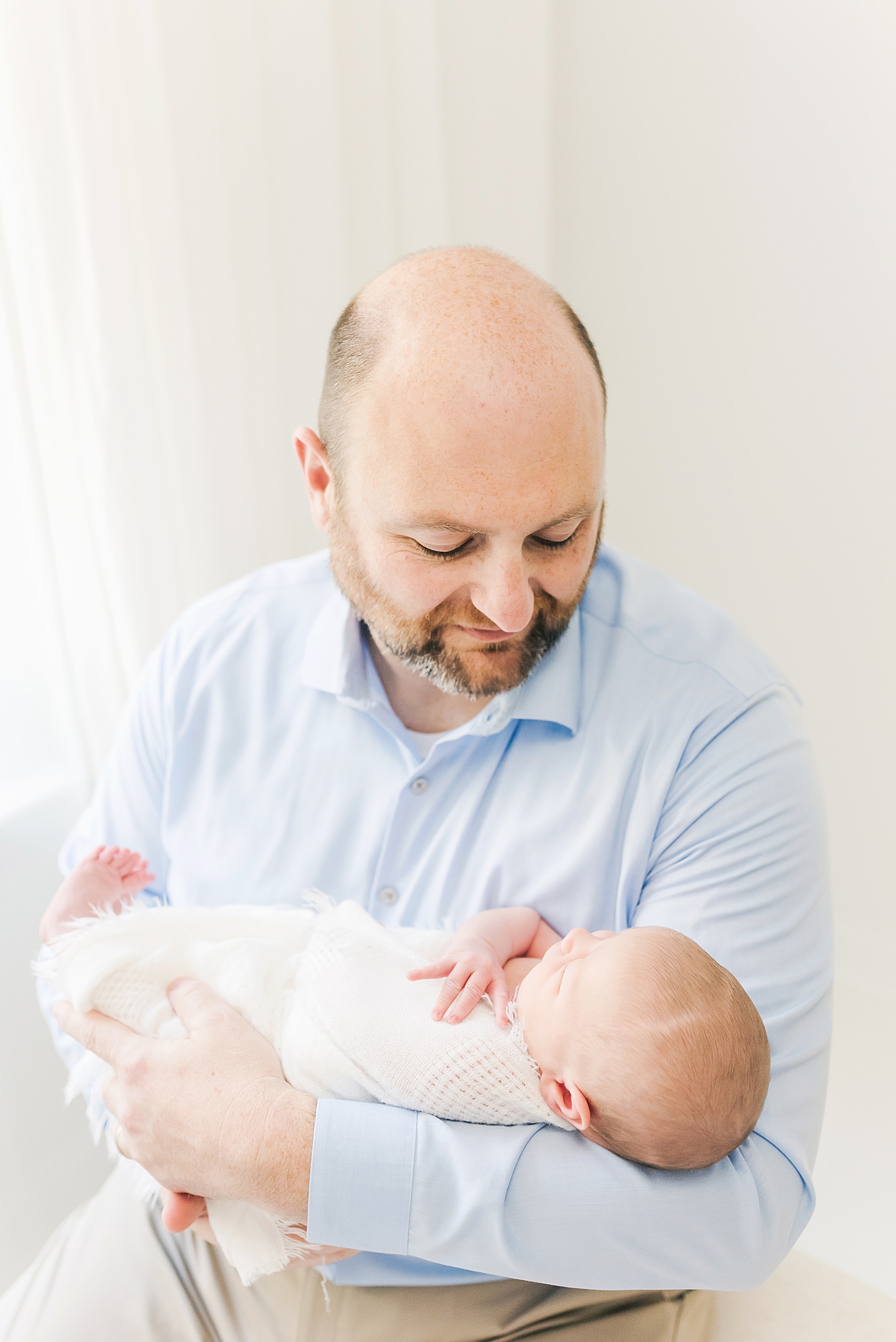 Baby boy in white swaddle held by dad | Anna Wisjo Photography - Baby Photographer Charlotte