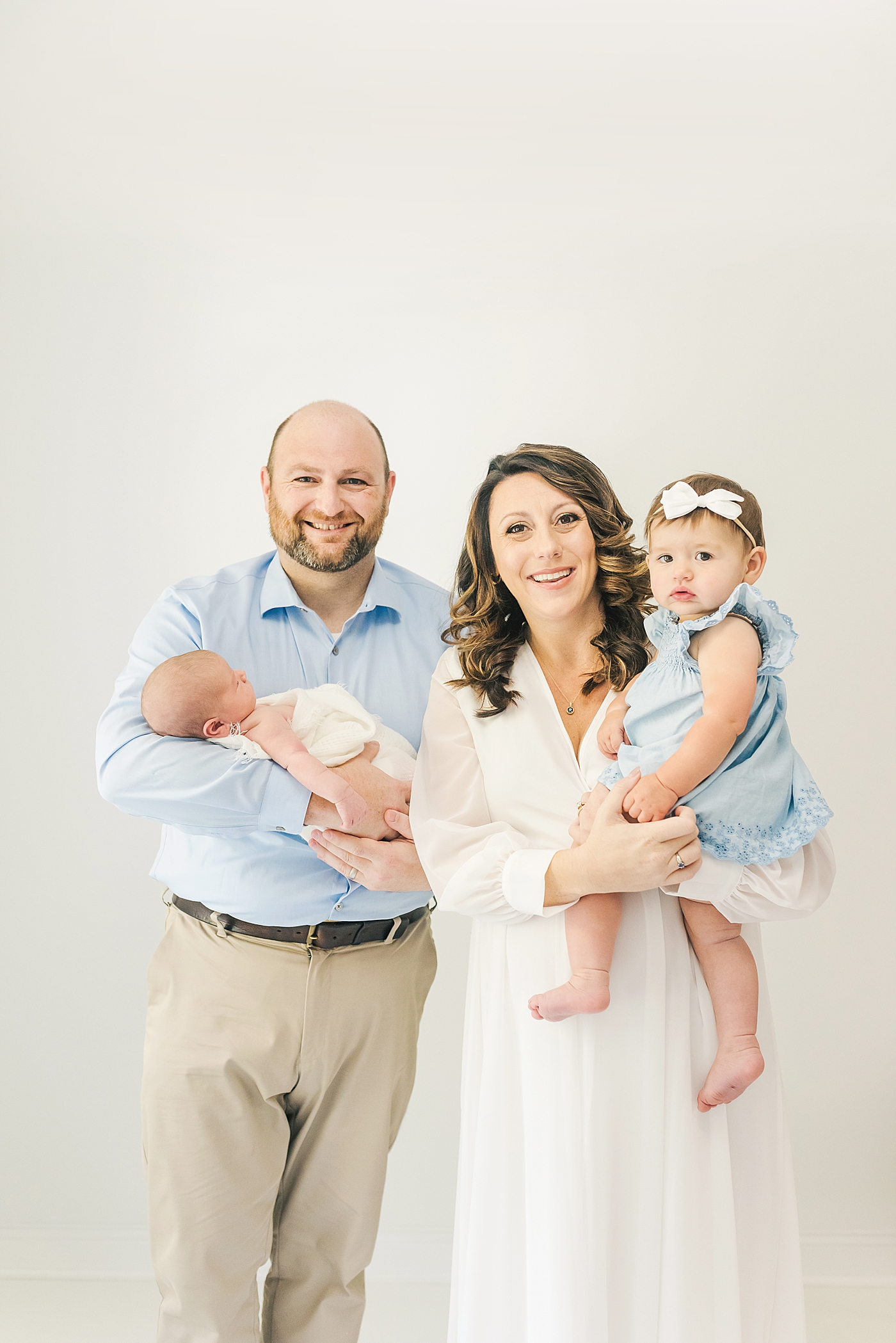 Family of four smiling during family portraits | Photo by Anna Wisjo Photography