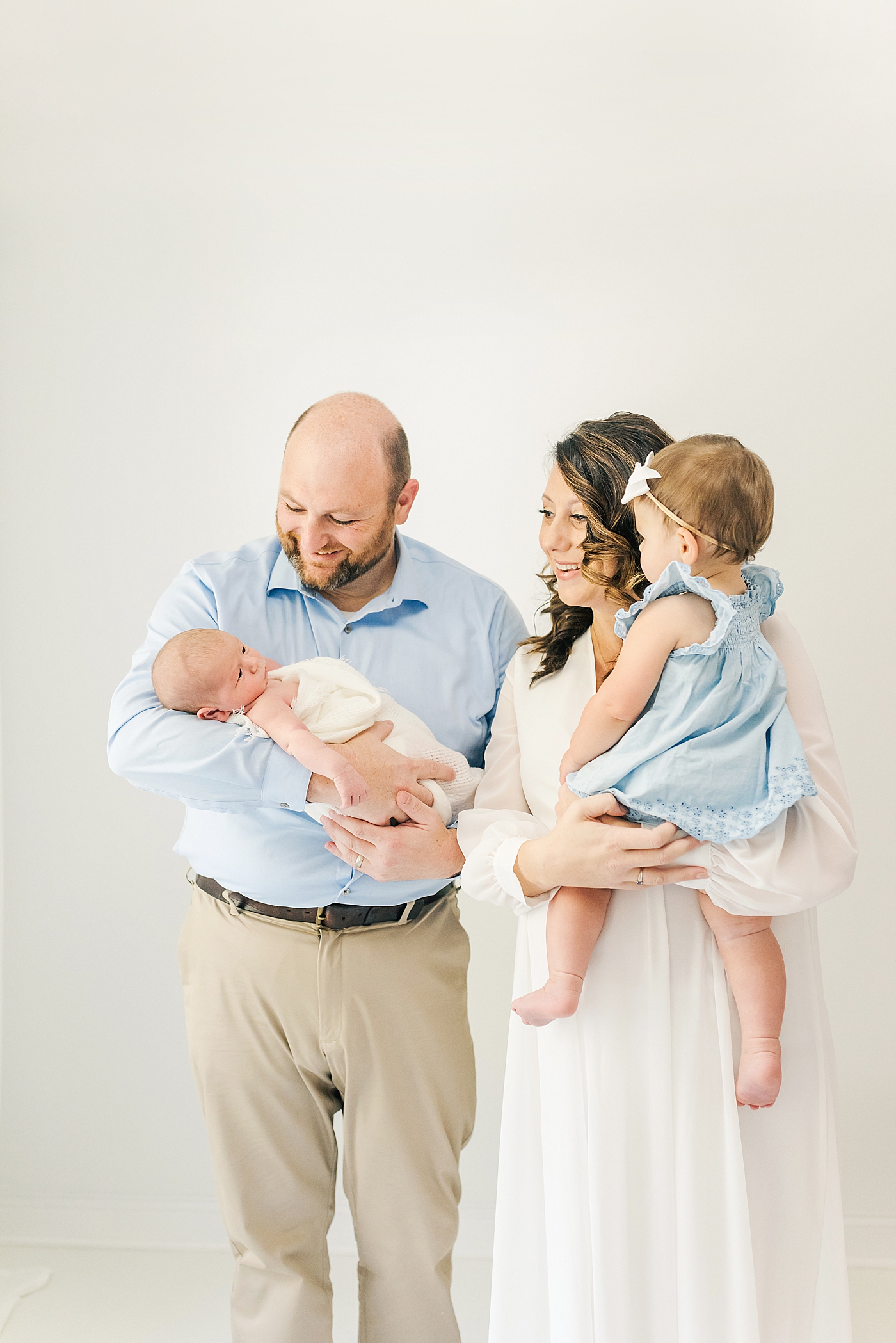 Family of four in blue and cream in the studio | Photo by Anna Wisjo Photography