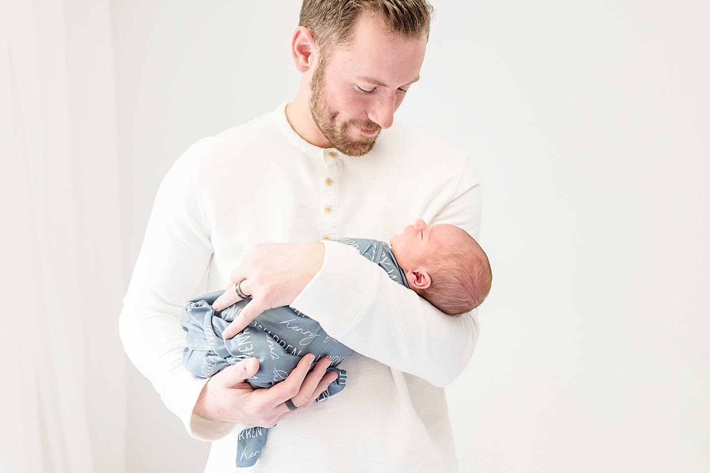 Dad in white shirt holding his new baby | Photo by Anna Wisjo Photography