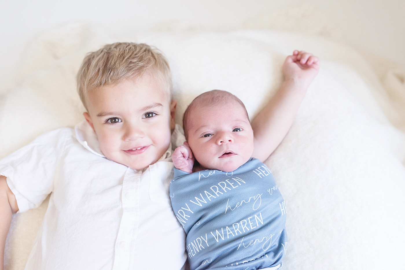 Big brother snuggling with his new brother in blue | Photo by North Carolina Newborn Photographer Anna Wisjo 