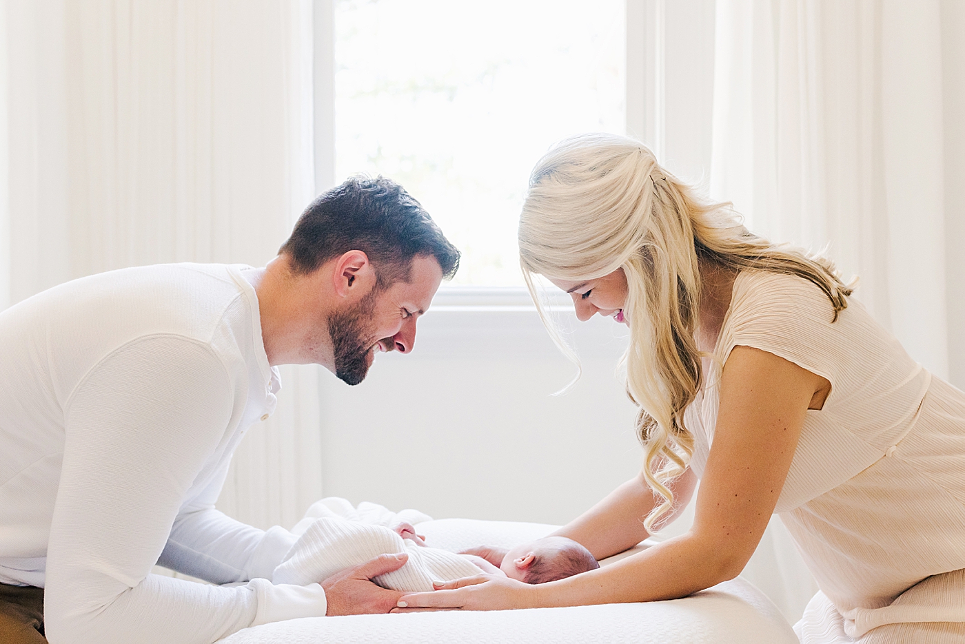 Mom and dad both holding their new baby | Photo by Ballantyne newborn photographer Anna Wisjo 