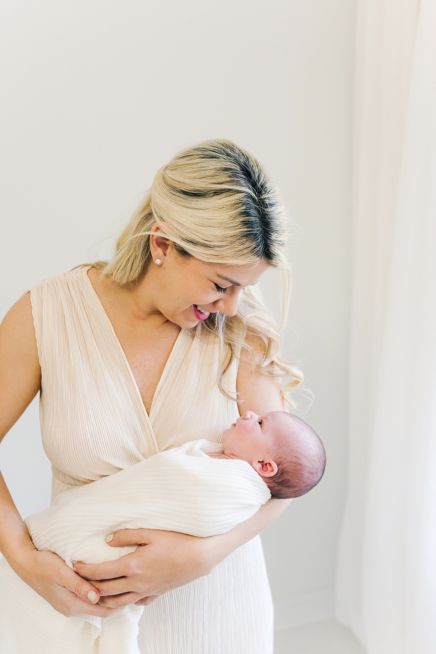 New mom holding her newborn baby | Photo by Anna Wisjo Photography