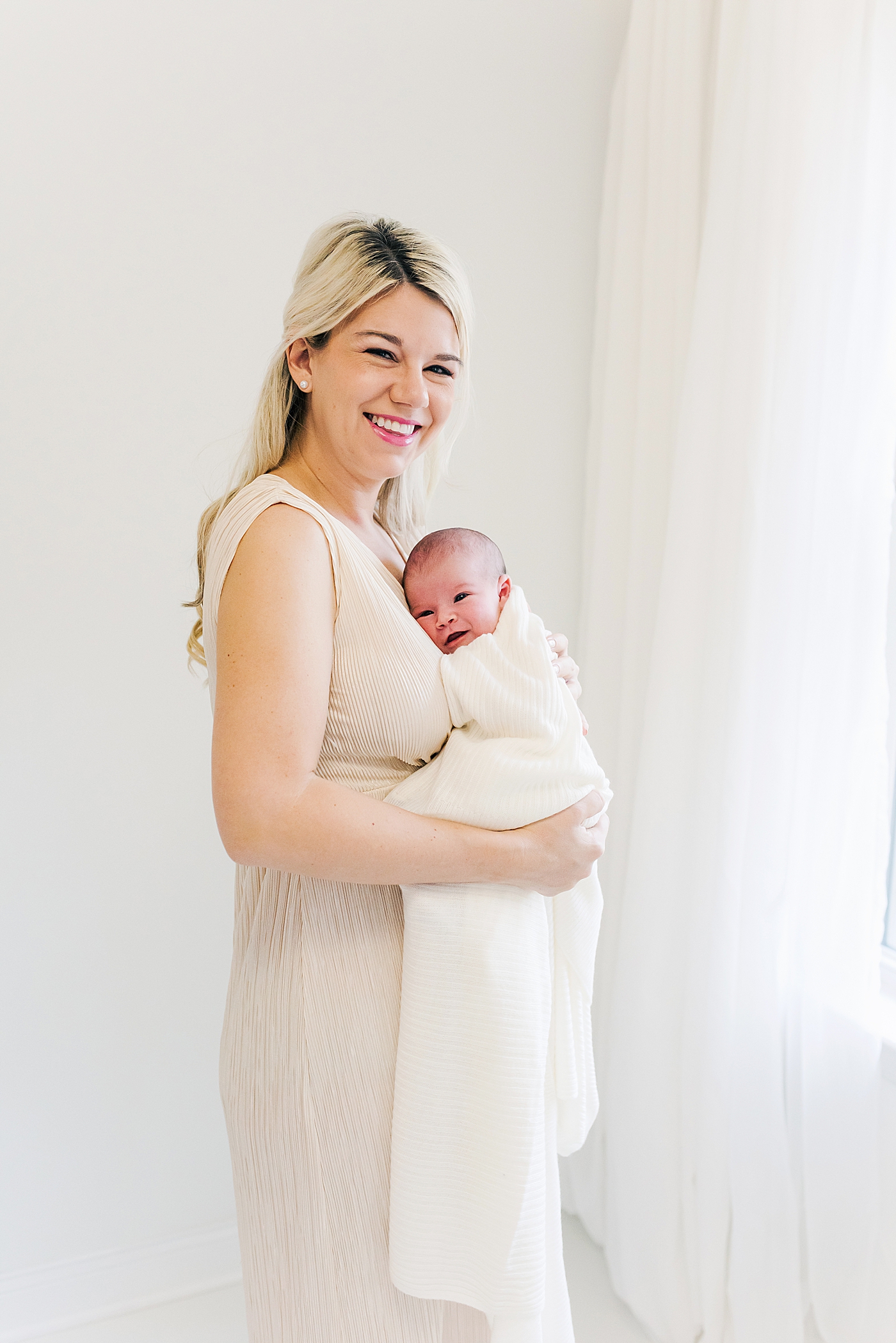 Mom smiling holding her new baby girl | Photo by Anna Wisjo Photography