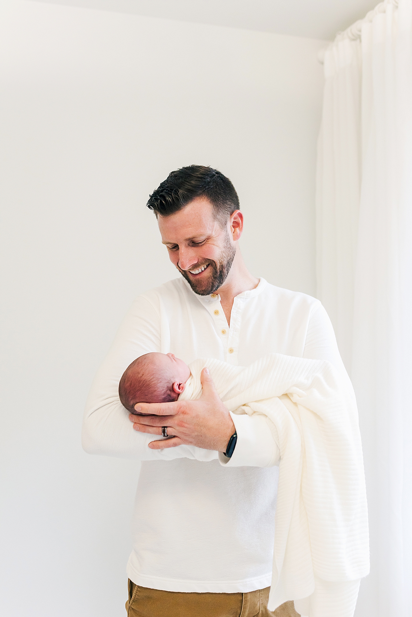Dad holding his new baby girl | Photo by Ballantyne newborn photographer Anna Wisjo 