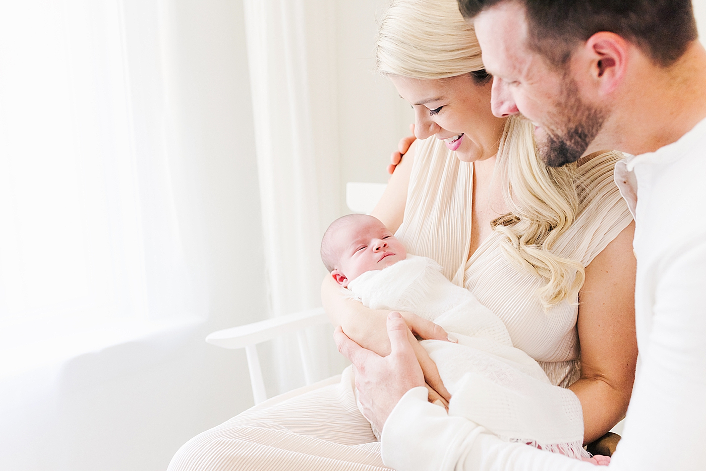 Mom and dad snuggling with their new baby | Photo by Ballantyne newborn photographer Anna Wisjo 