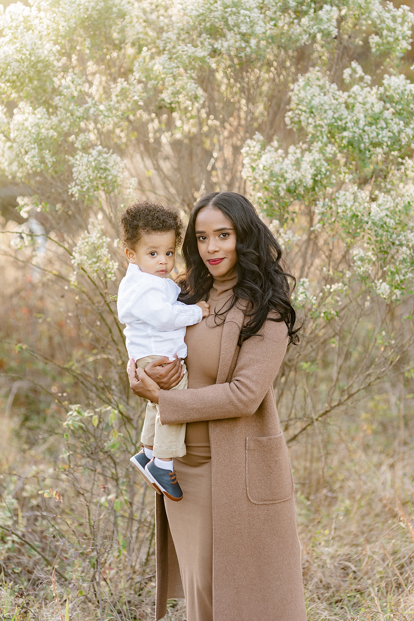 Mom in brown holding her baby boy | Photo by Anna Wisjo Photography