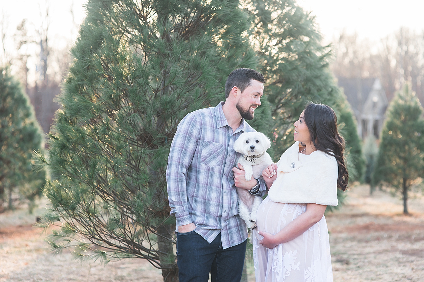 Mom and dad to be holding their dog at the tree farm | Photo by Anna Wisjo Photography