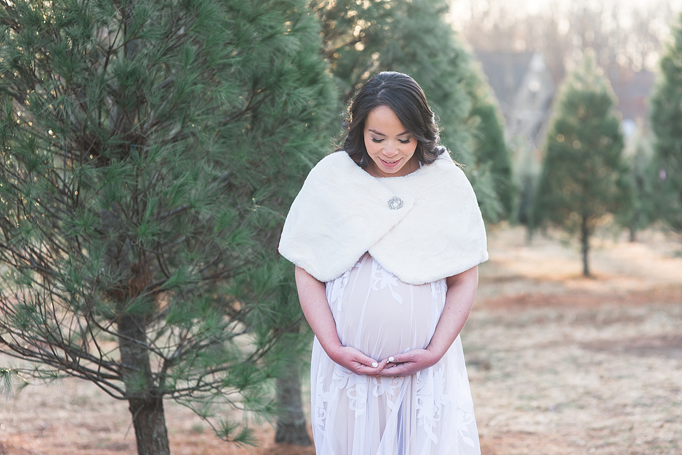 Mom to be in white holding her belly | Photo by Anna Wisjo Photography