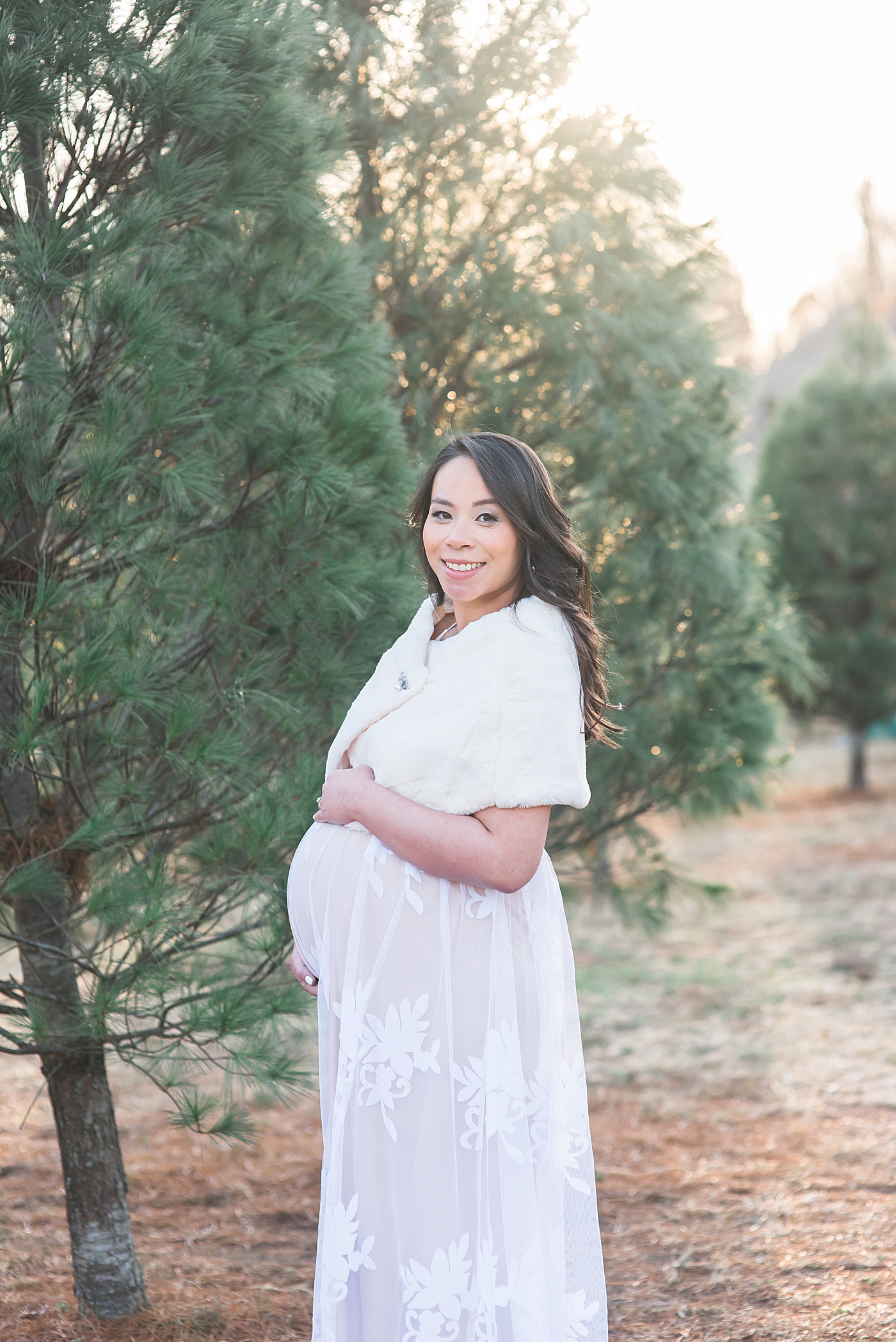 Mom to be in white shawl and lace dress smiling | Photo by Anna Wisjo Photography