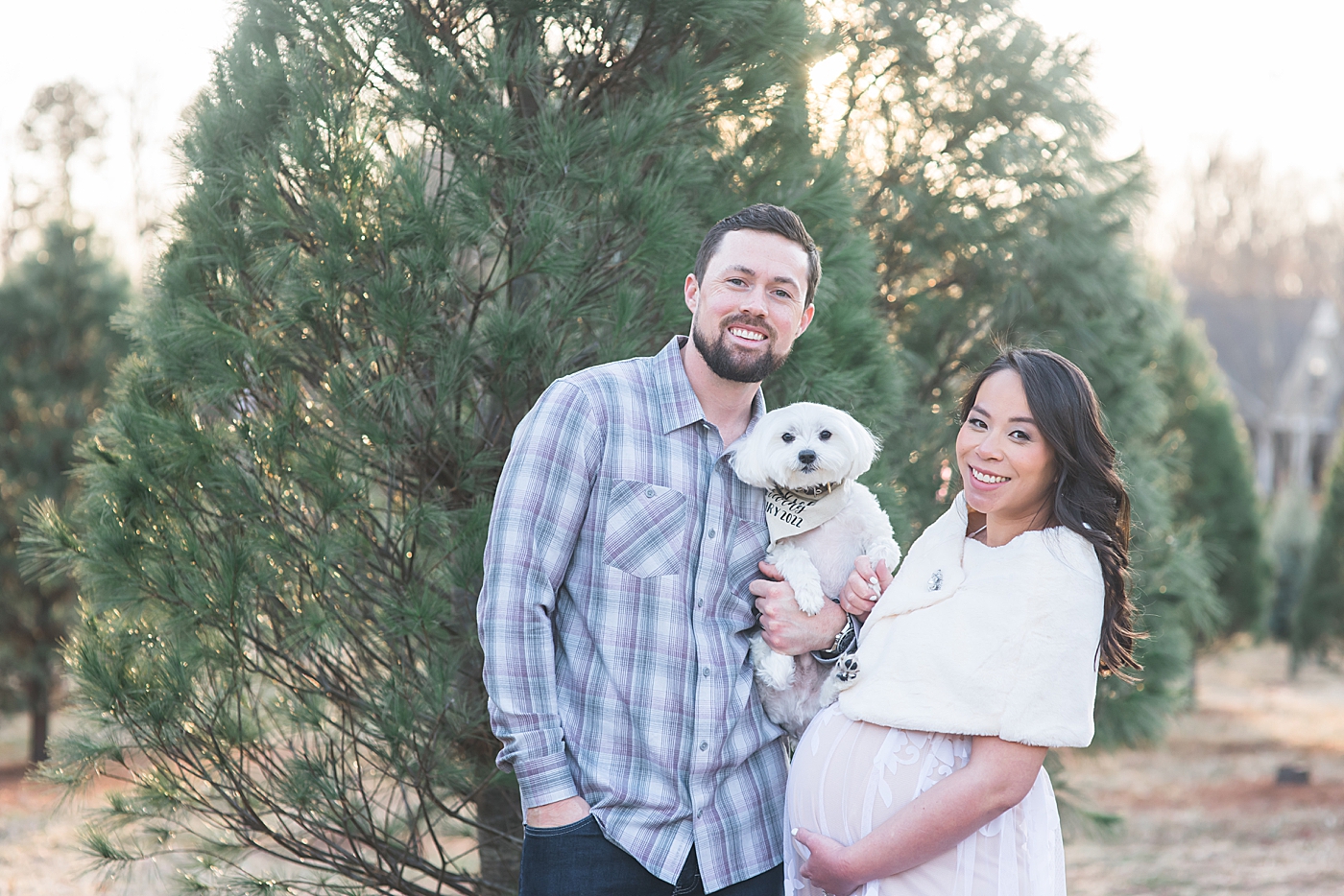 Mom and dad to be holding their white puppy | Photo by Anna Wisjo Photography