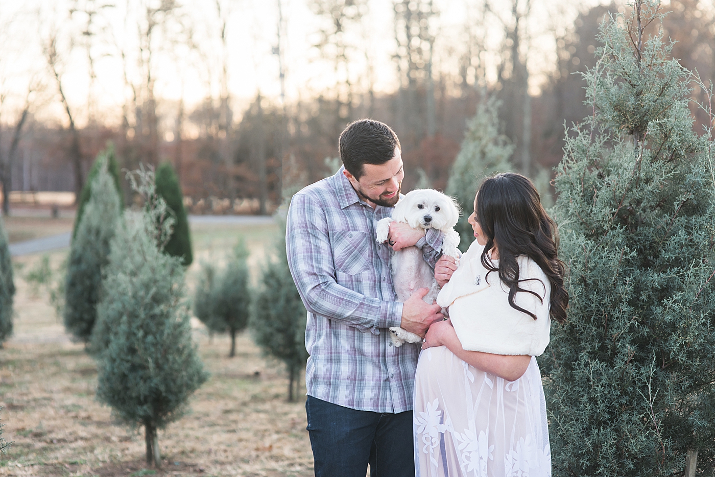 Family snuggling their dog at a tree farm | Photo by Anna Wisjo Photography