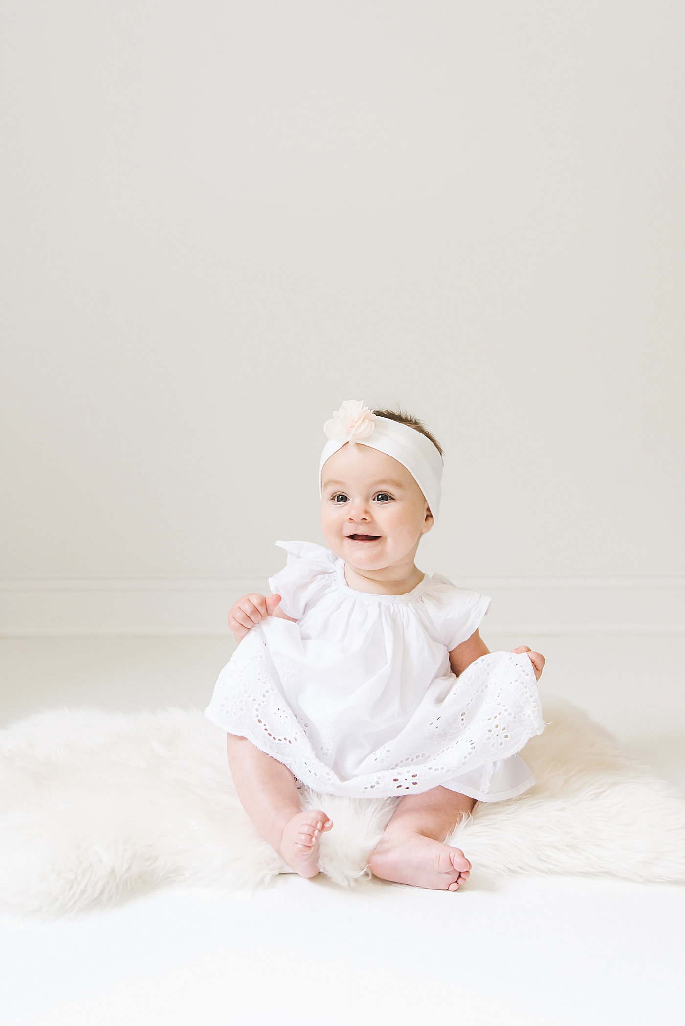 Baby girl in white dress sitting in the studio | Baby photographer in Charlotte Anna Wisjo