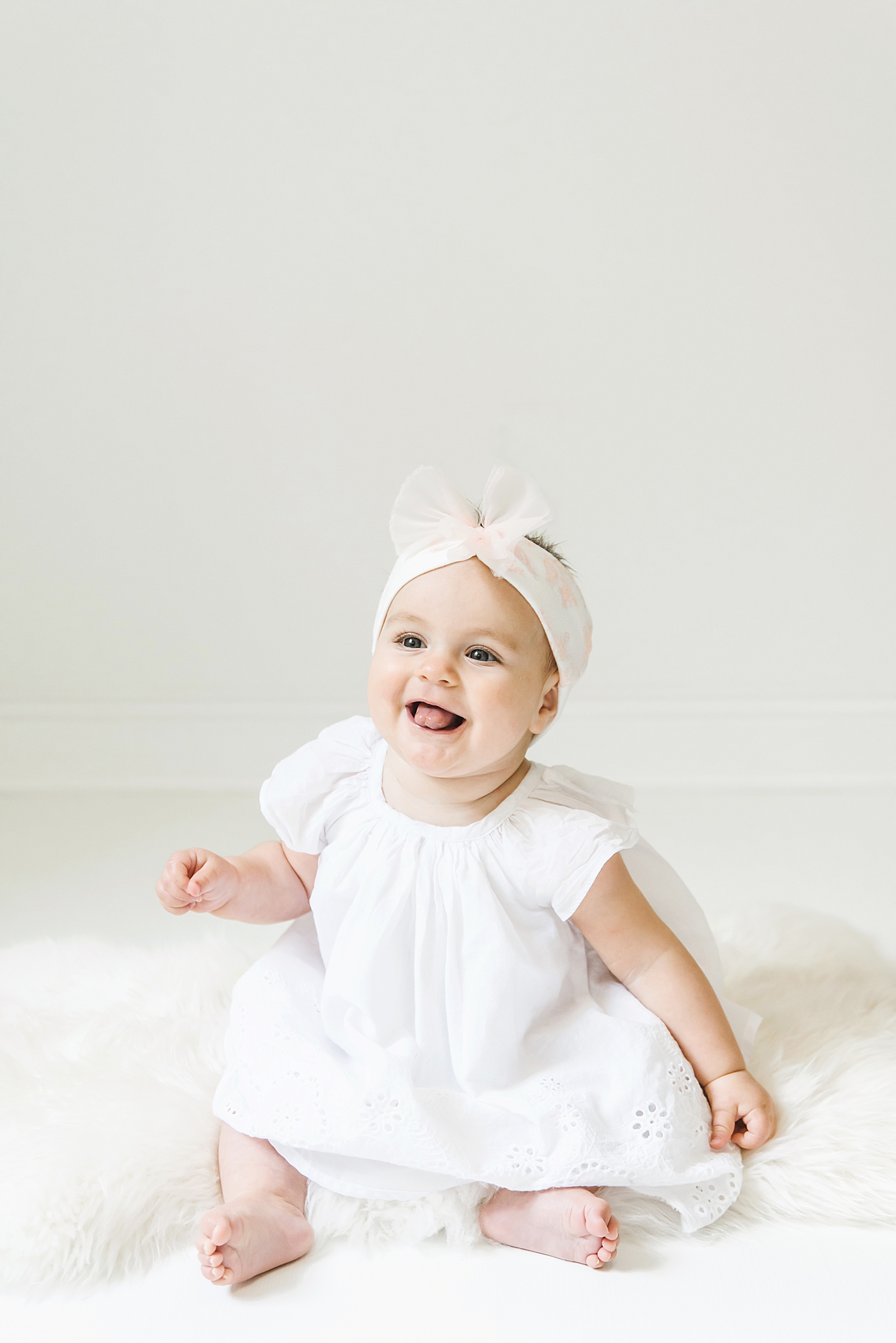 Baby girl in pink and white sitting in the studio | Photo by Anna Wisjo Photography