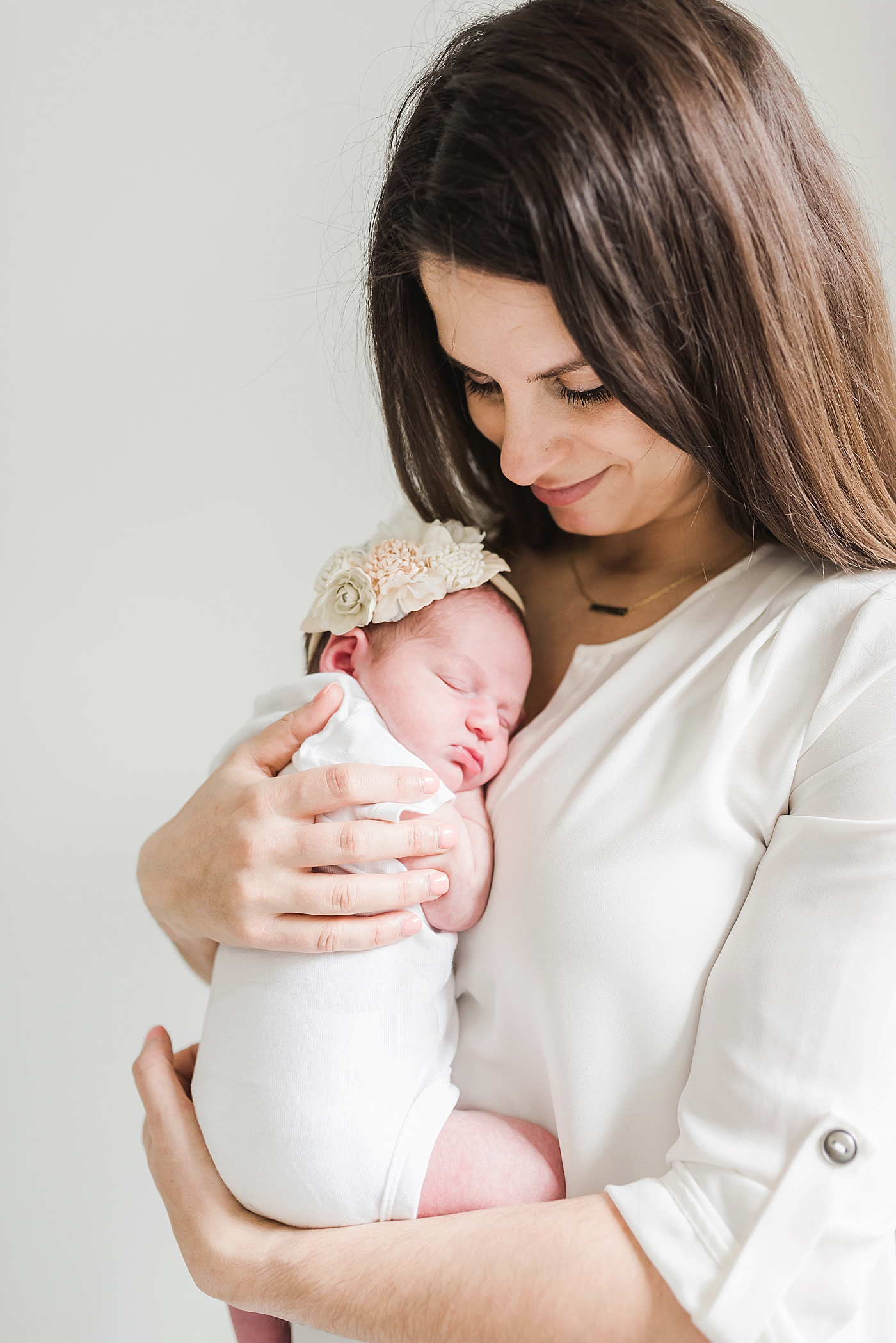 Mom holding her newborn baby girl | Photo by Anna Wisjo Photography