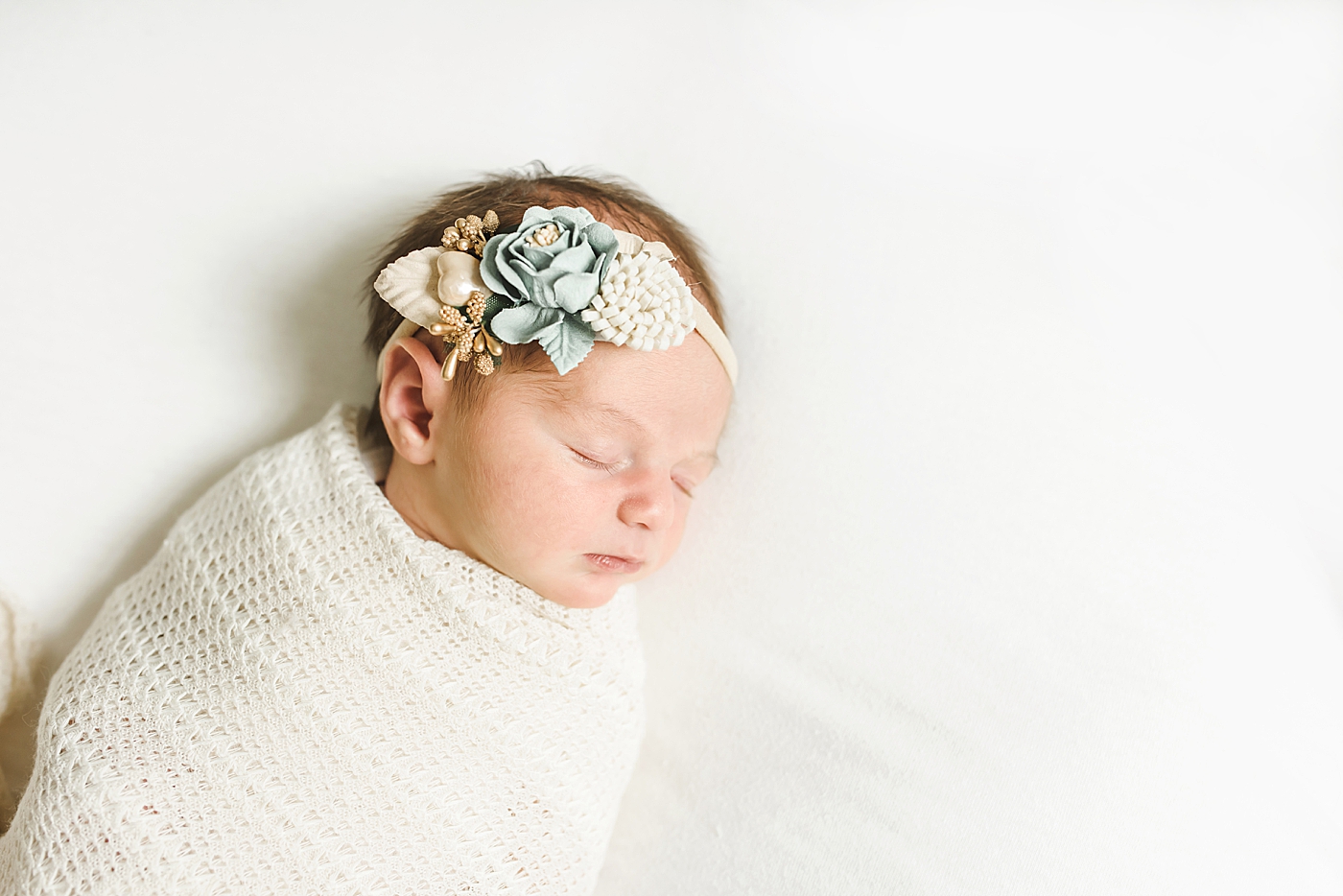 Newborn baby girl with bow asleep | Photo by Anna Wisjo Photography