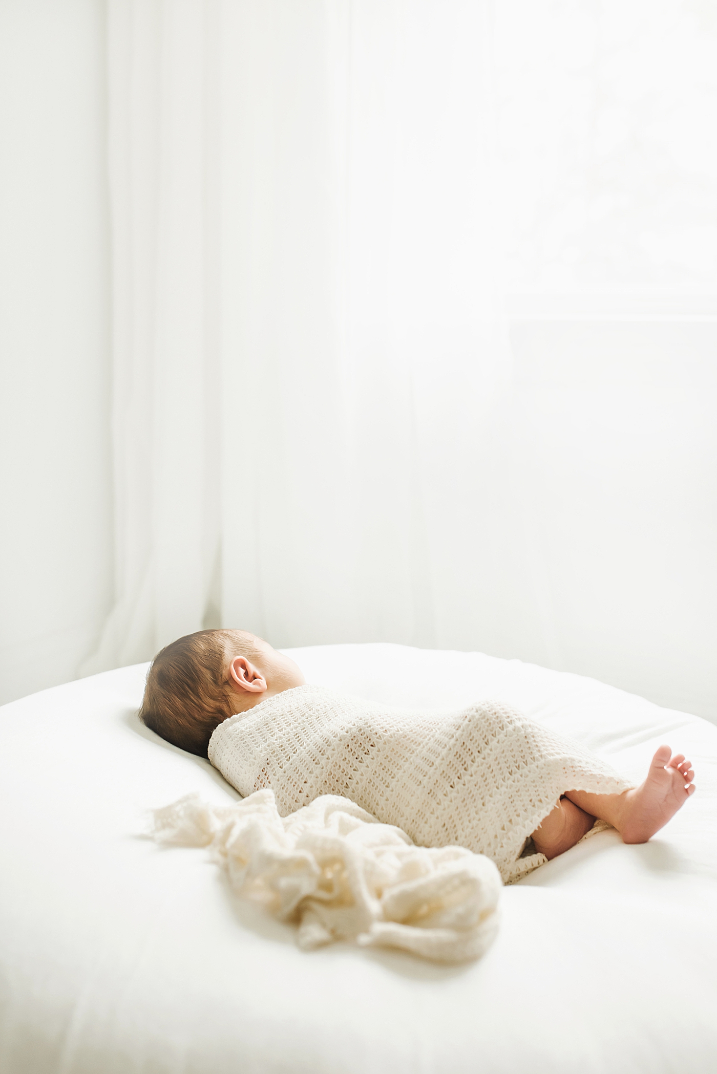 Baby girl sleeping wrapped in a white crochet blanket | Baby photographer in Charlotte Anna Wisjo
