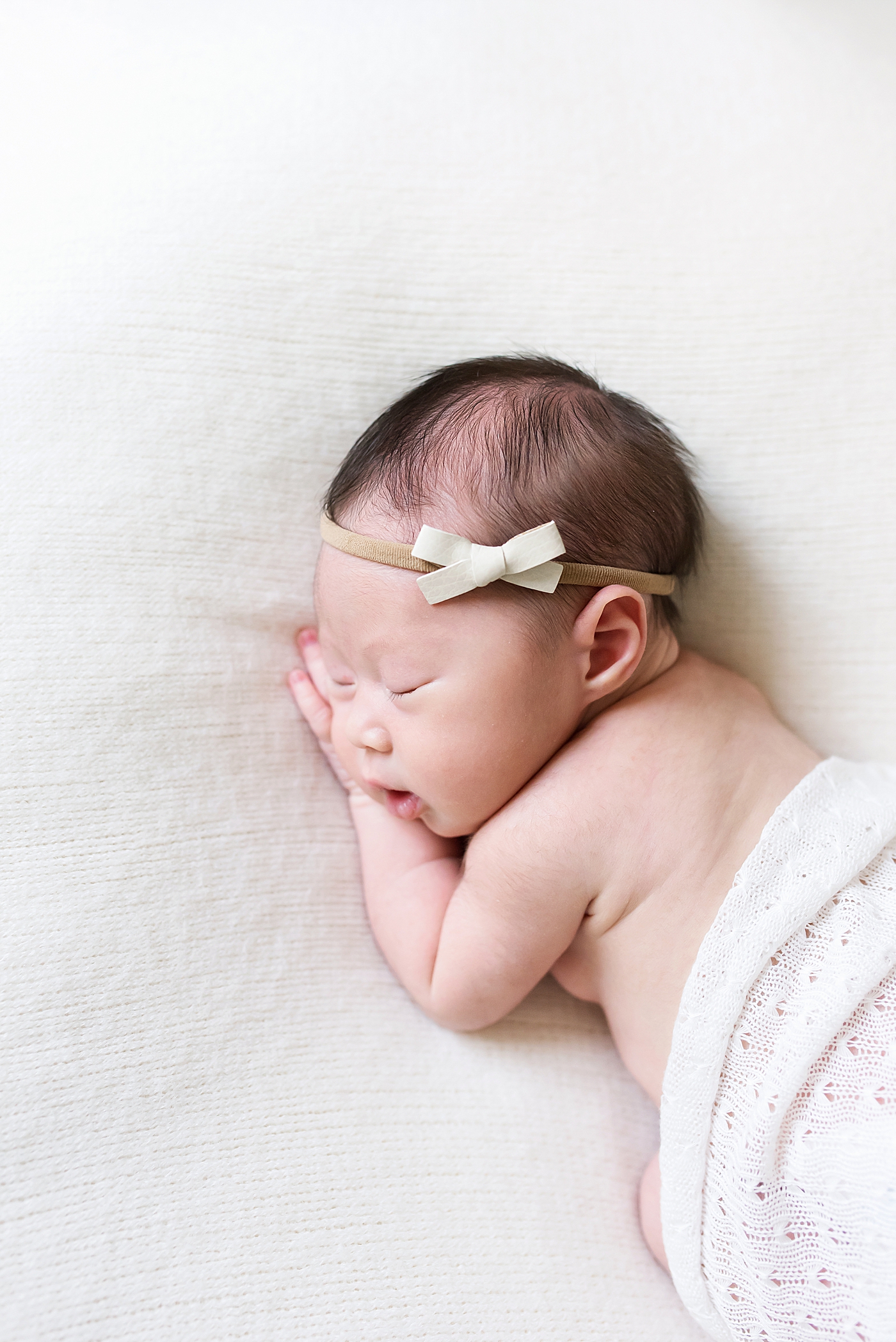 Sleeping baby girl wearing a green bow headband | Photo by Anna Wisjo Photography