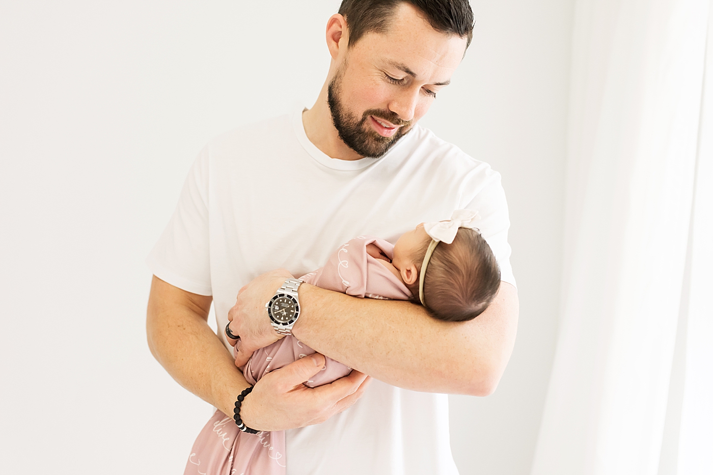 Dad holding his newborn baby girl during newborn studio session| Photo by Anna Wisjo Photography